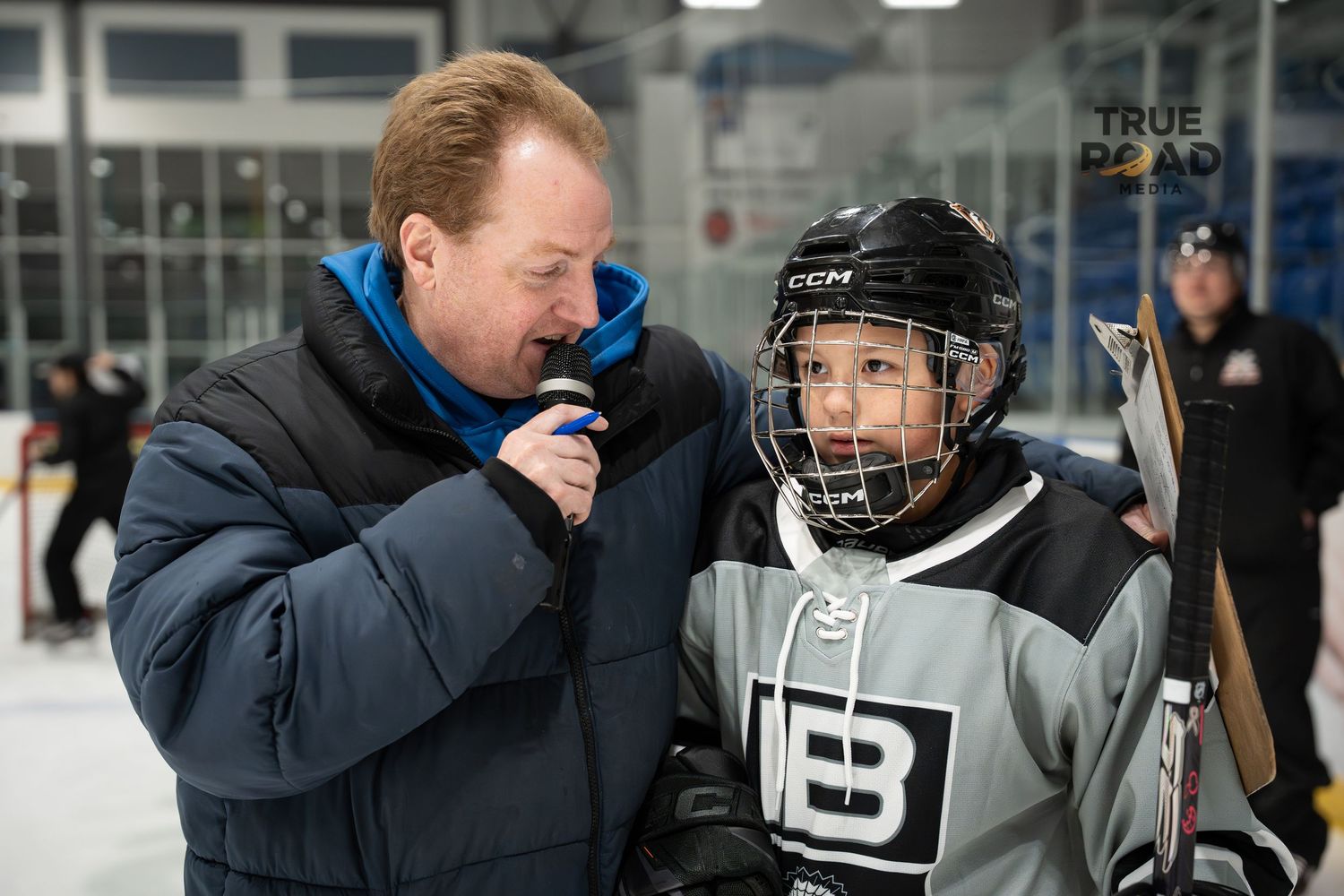 Players and coaches gathered on the ice during a hockey practice session.