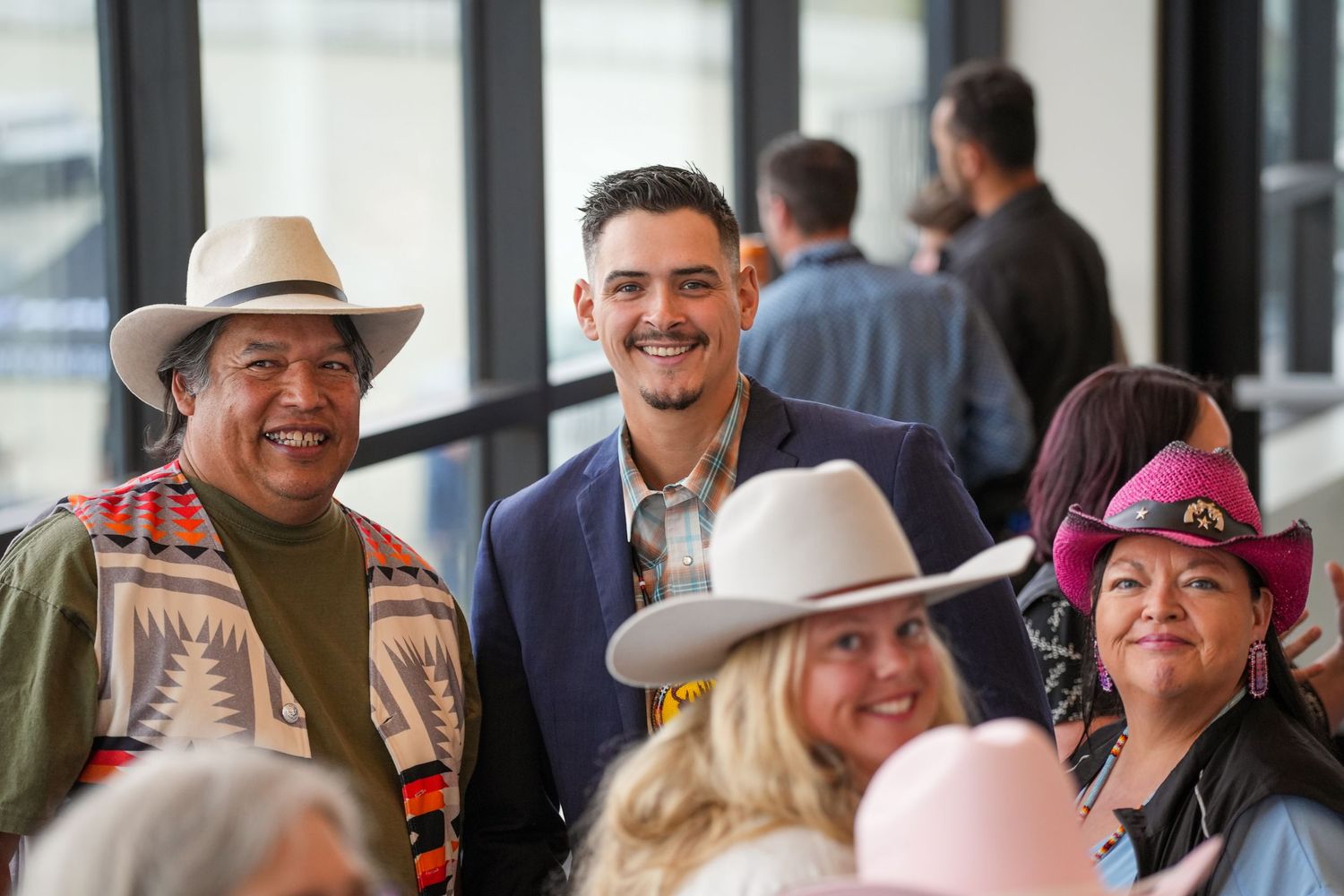 People socializing and smiling at an indoor event.