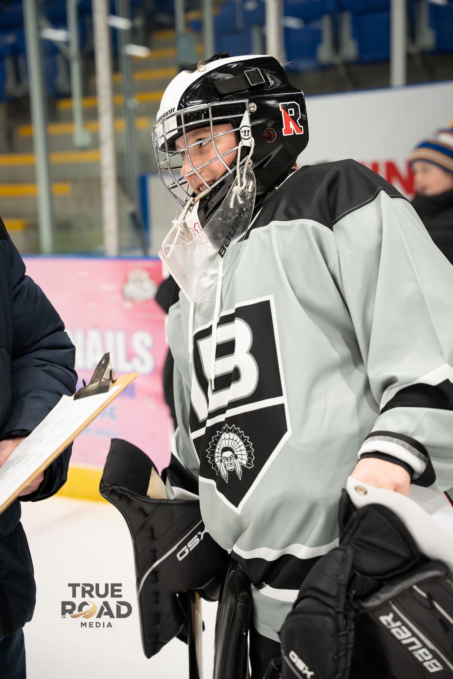 Hockey players in gray and black jerseys skate on ice during practice.