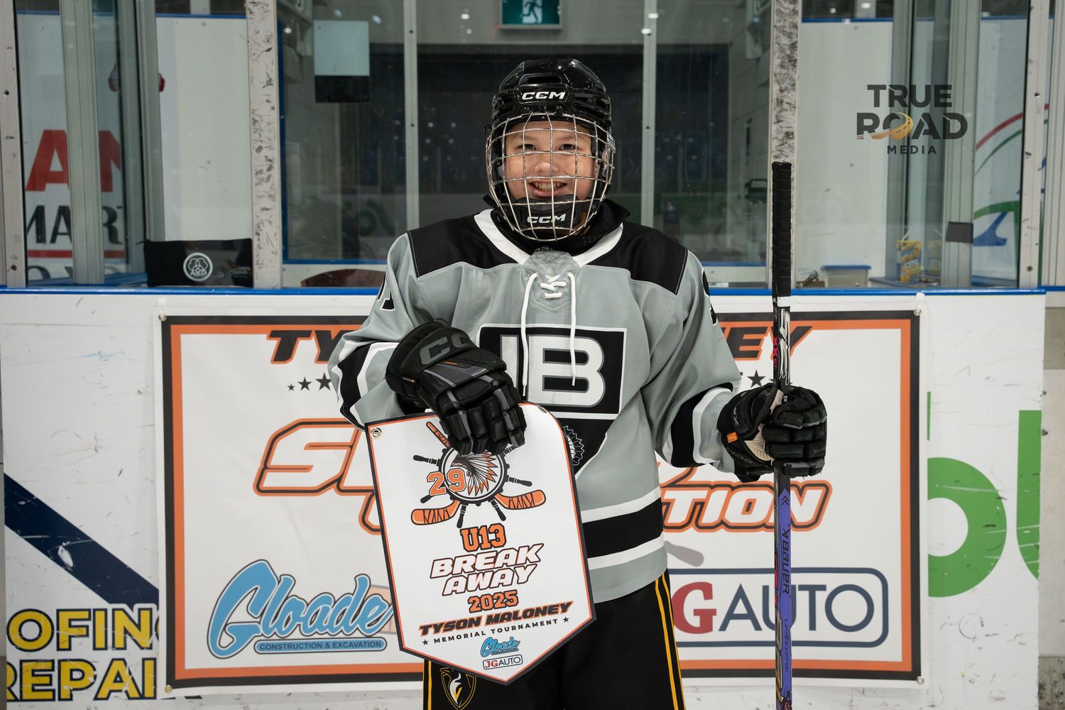 Hockey players practicing on ice with arena advertisements and boards visible in background.