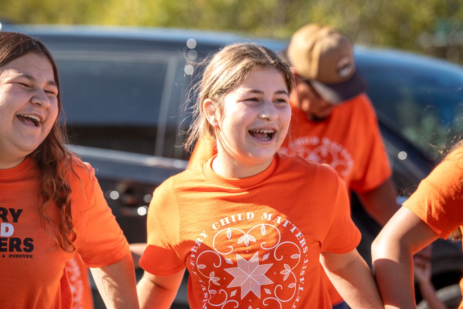 Large group of supporters wearing matching orange shirts at a gathering.