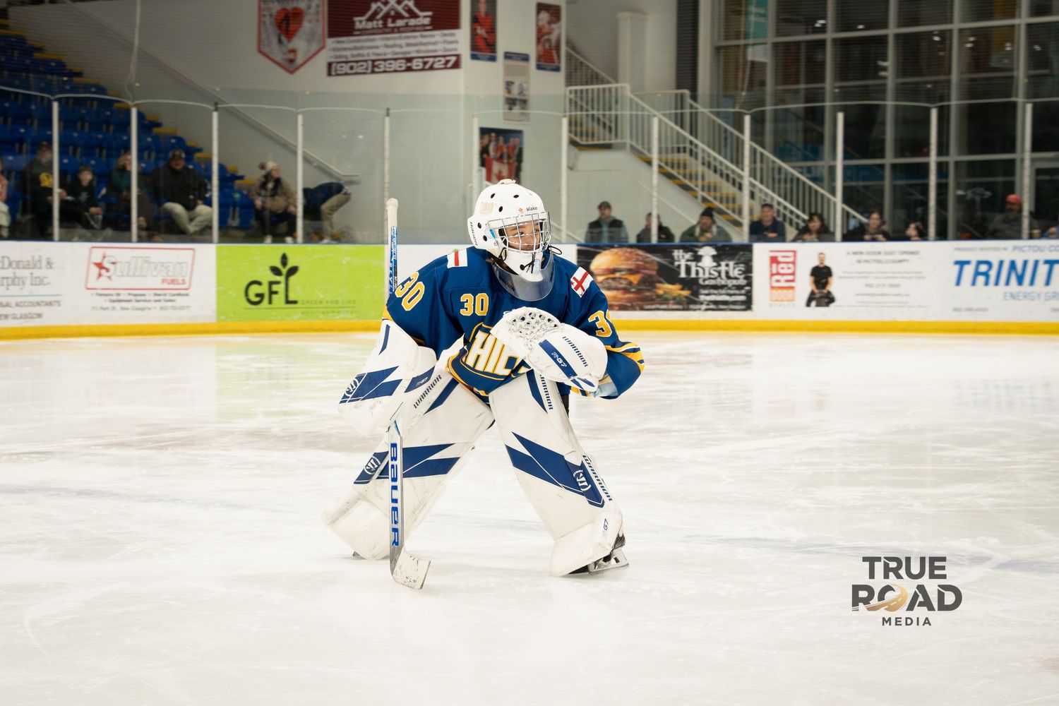 Hockey players in blue and white uniforms compete for the puck during an intense game on the ice.