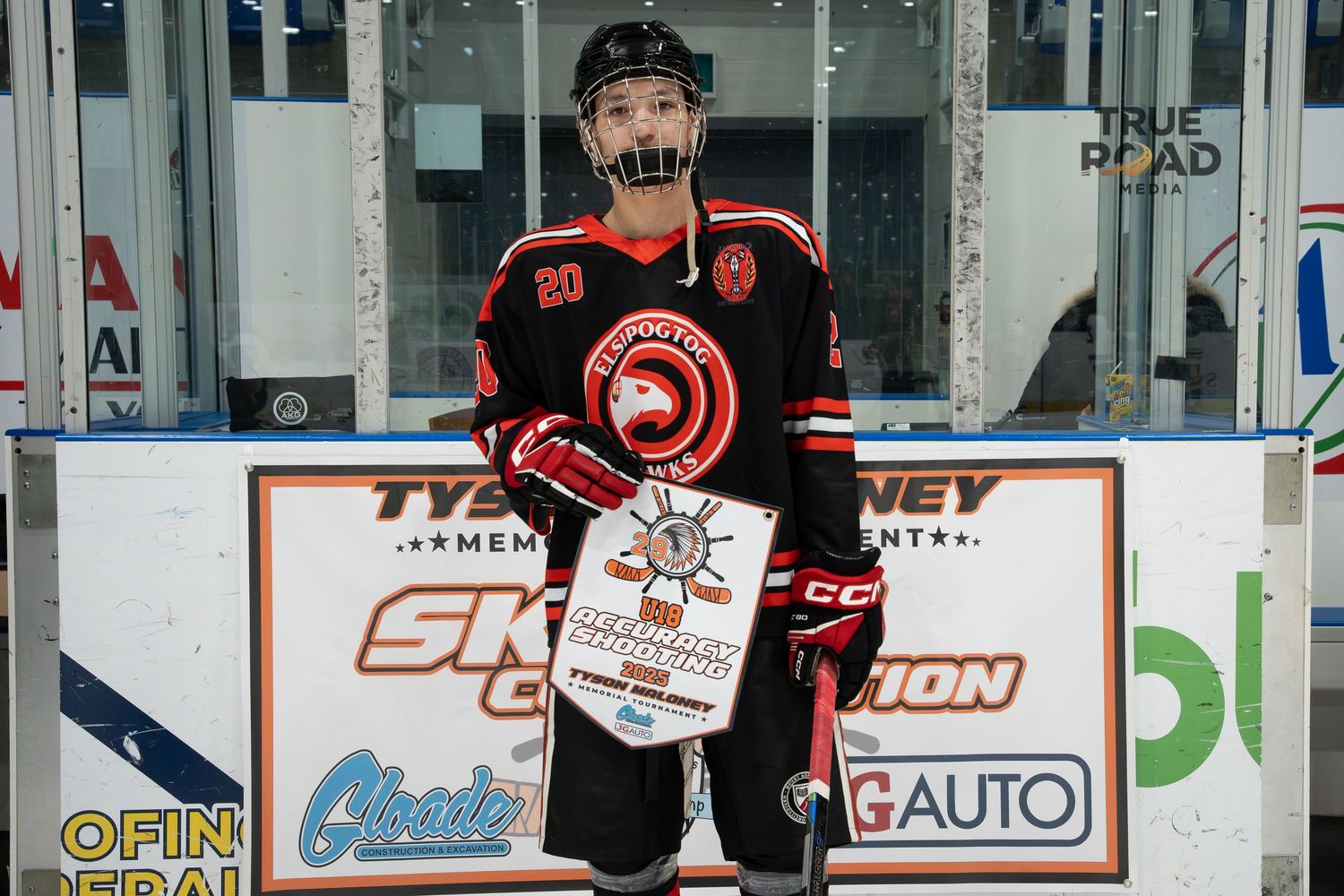 A hockey player in a black and orange jersey skates on the ice during a game.