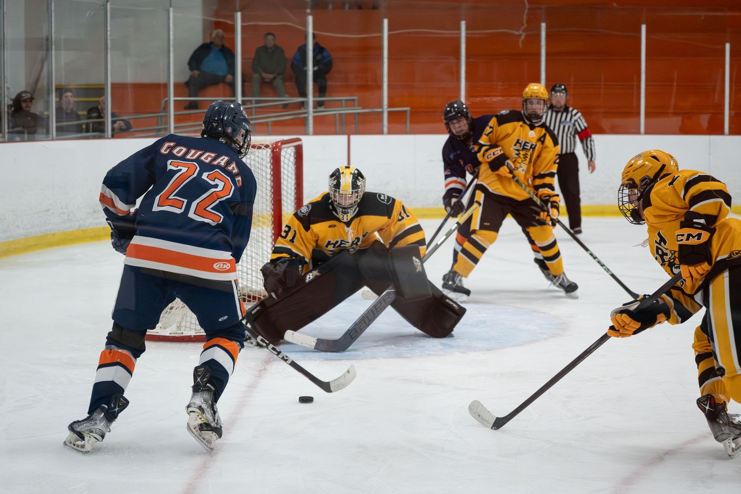 Hockey players from opposing teams battle for the puck during an intense ice hockey game.