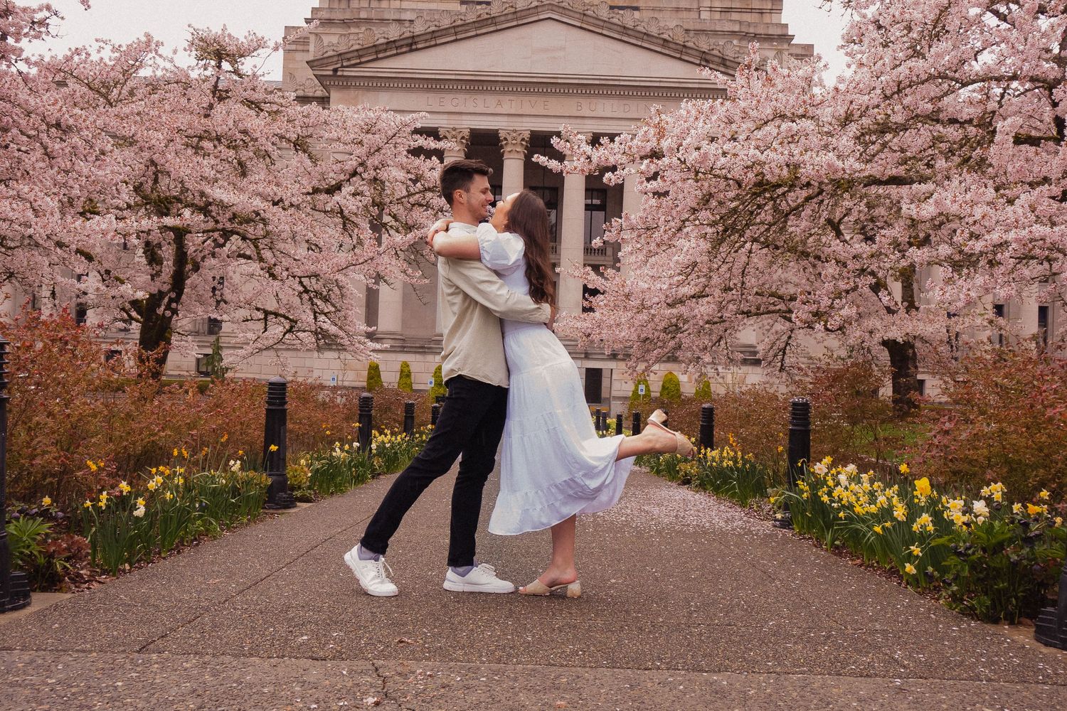 Cherry blossoms frame a romantic spring wedding photoshoot in a beautiful garden setting.