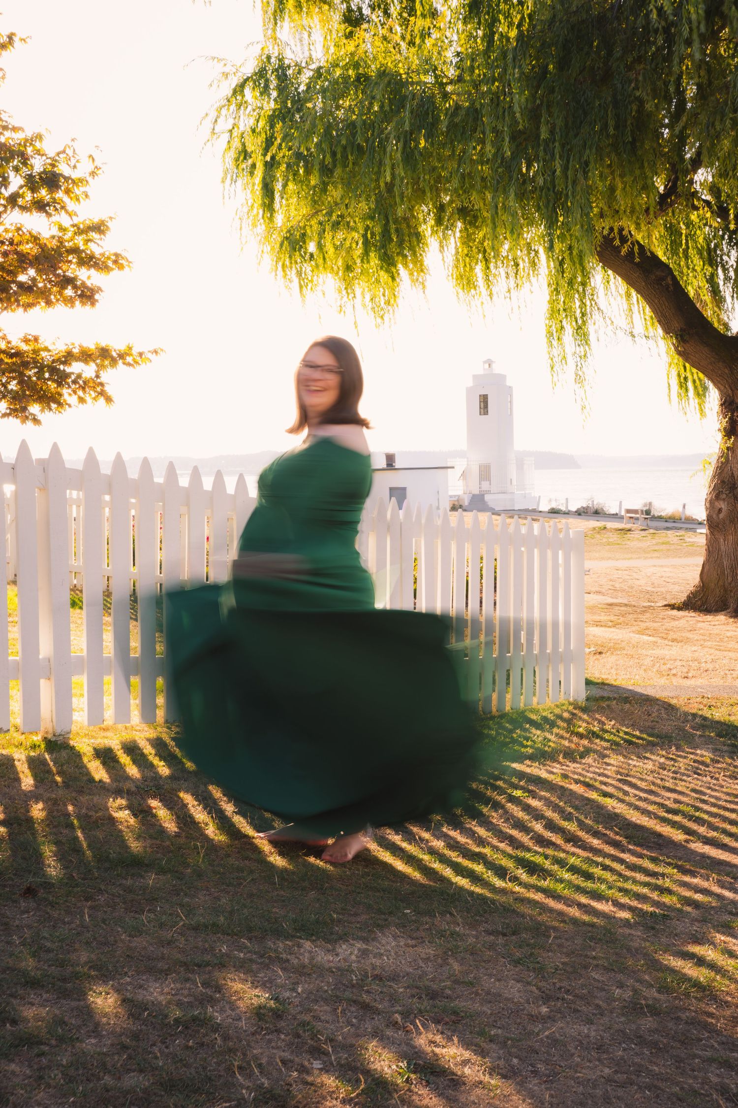 A sequence of motion shots showing a person in green swinging back and forth beneath a willow tree at sunset.