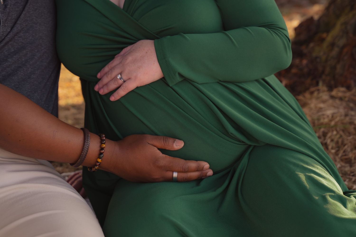 A series of photos showing hands cradling a pregnant belly wearing a green maternity dress.