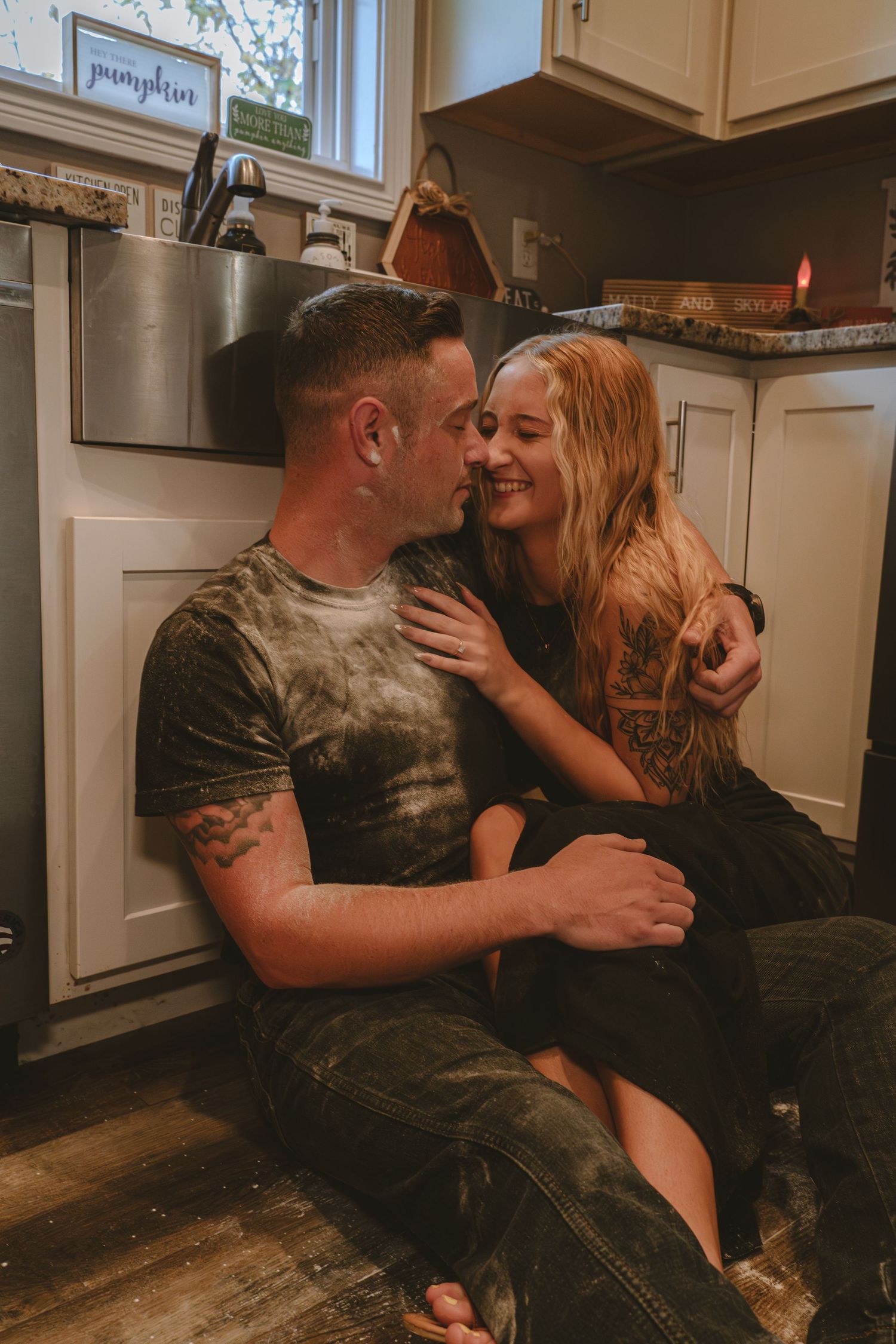 A romantic moment captured in a cozy kitchen setting.
