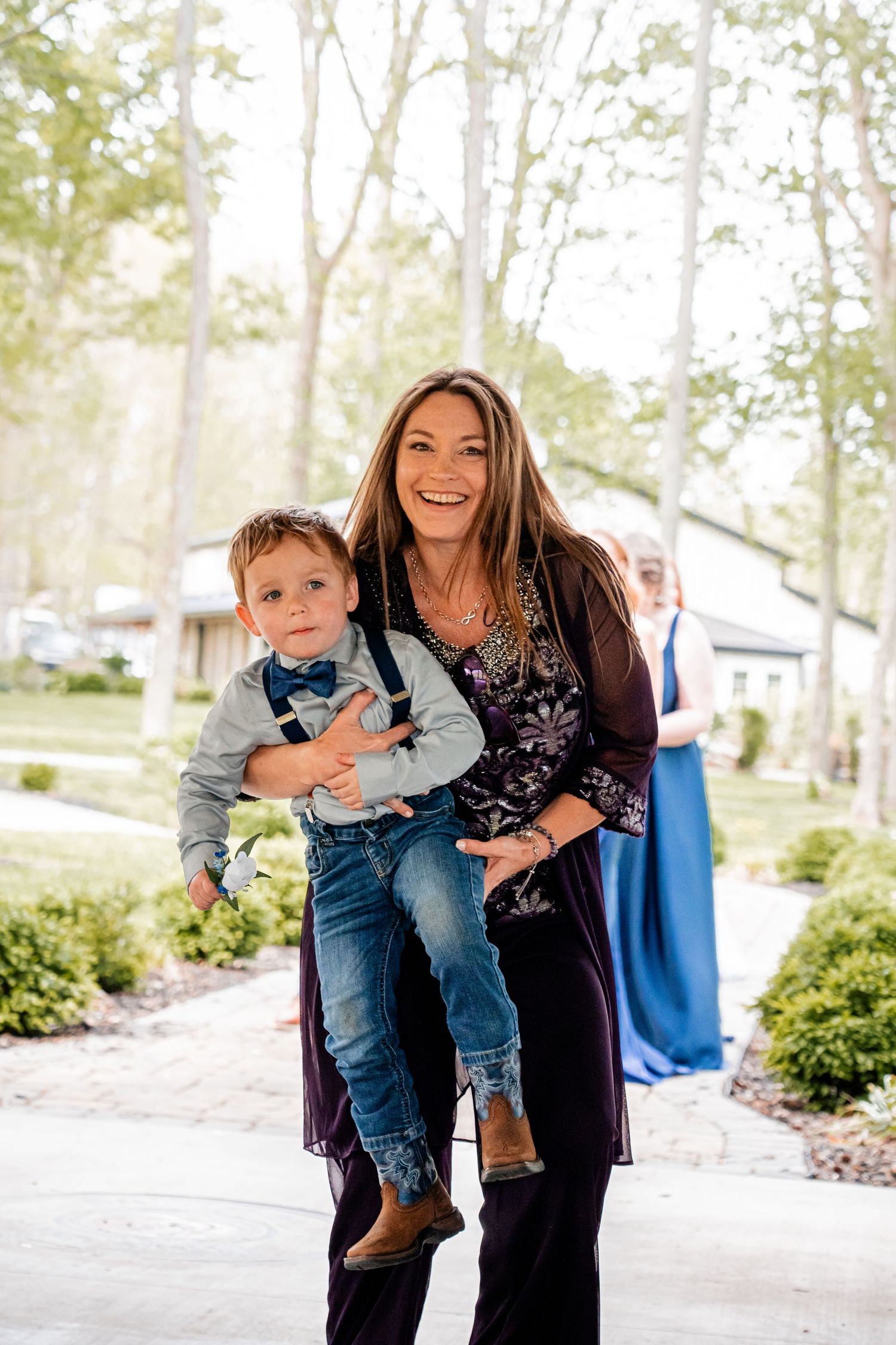 Joyful moment captured outdoors with formal attire against residential background.
