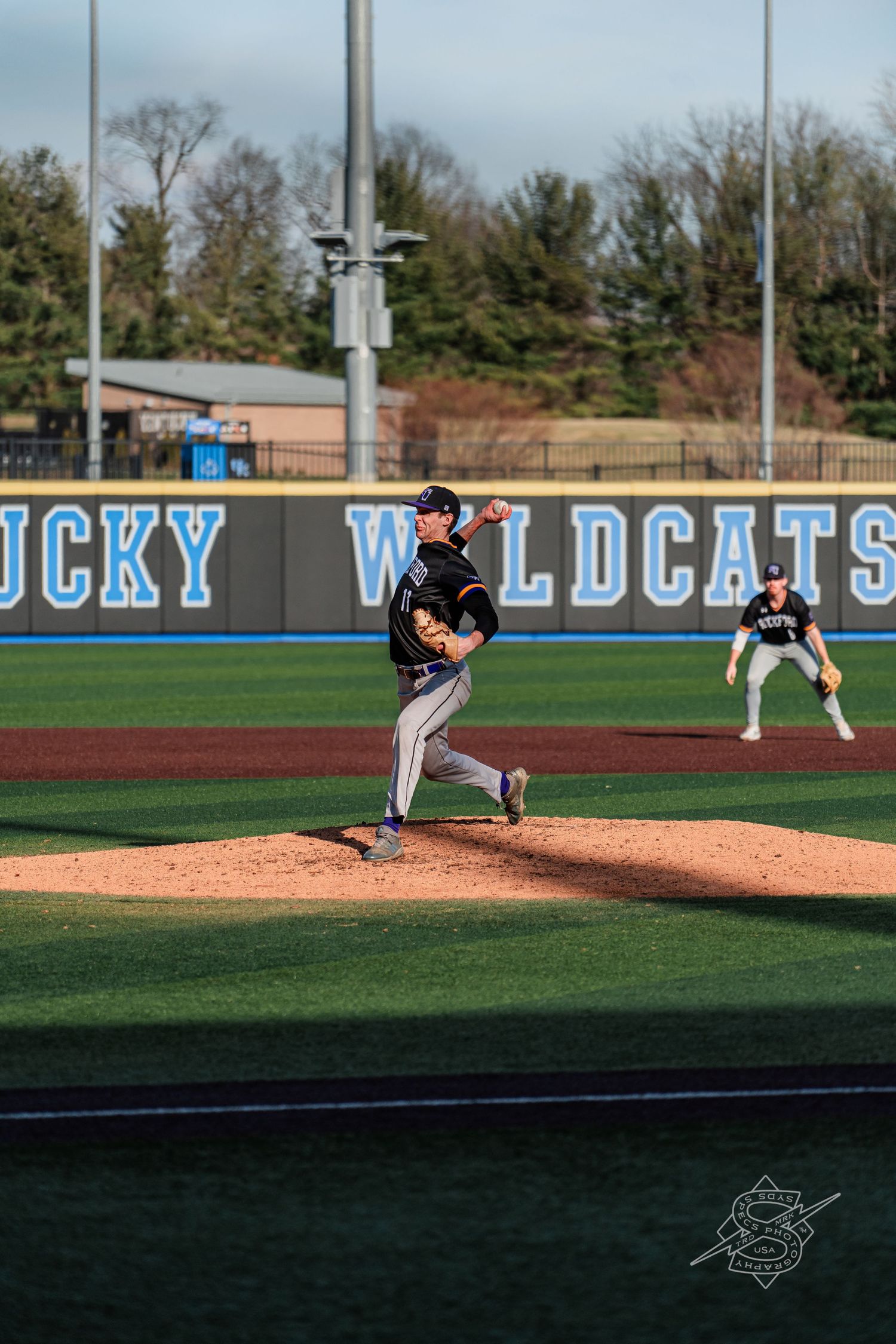 Baseball pitcher in mid-delivery throws from the mound during a game.