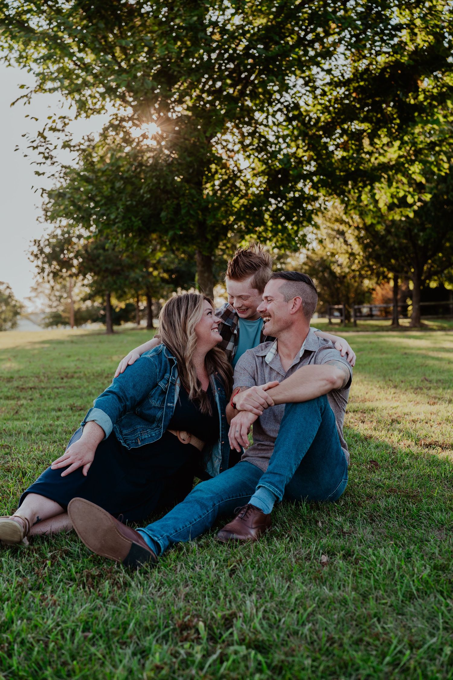 Intimate couple lounging together on grass during a sunny autumn afternoon.