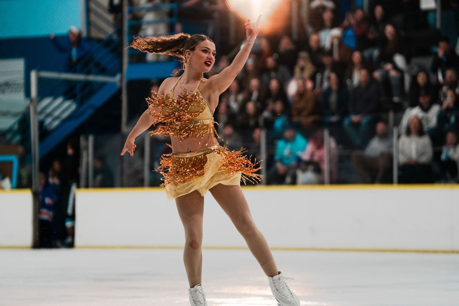 Figure skater performing on ice in a sparkling costume during competition.