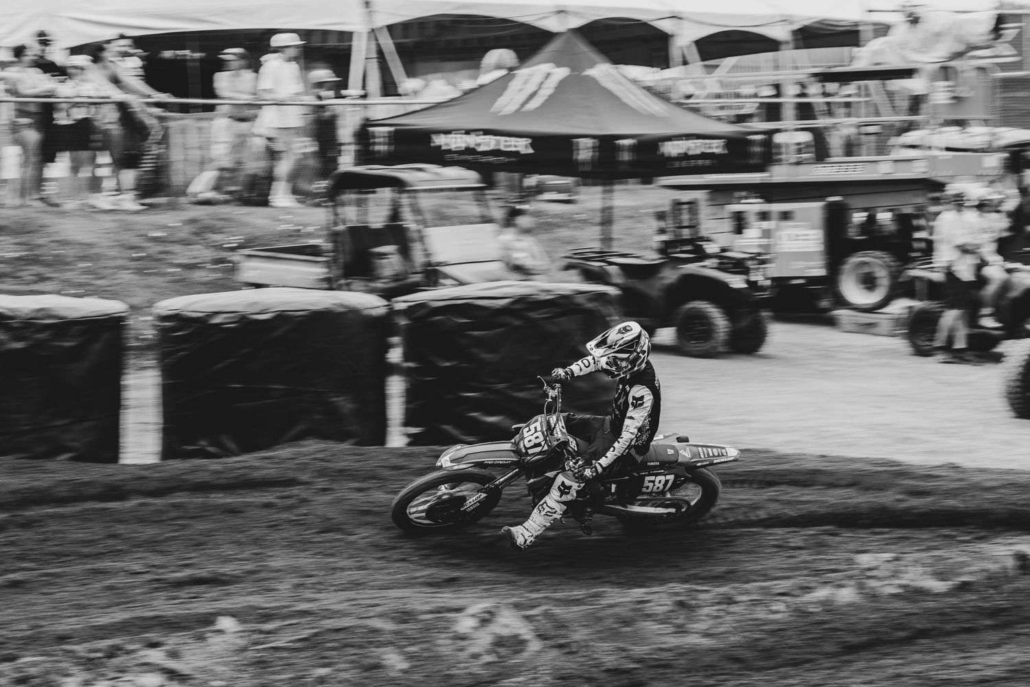 Motorcycles racing and jumping on a dirt track during a motocross competition.