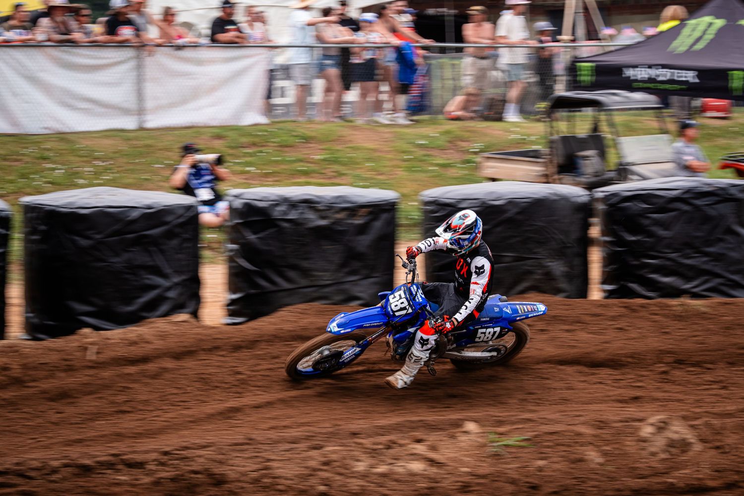 A dirt bike rider navigates a challenging dirt track during a motocross competition.