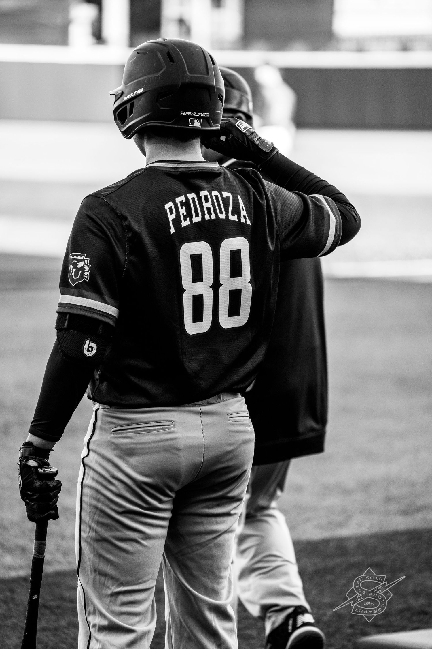Baseball players wearing jerseys with numbers stand together in black and white.