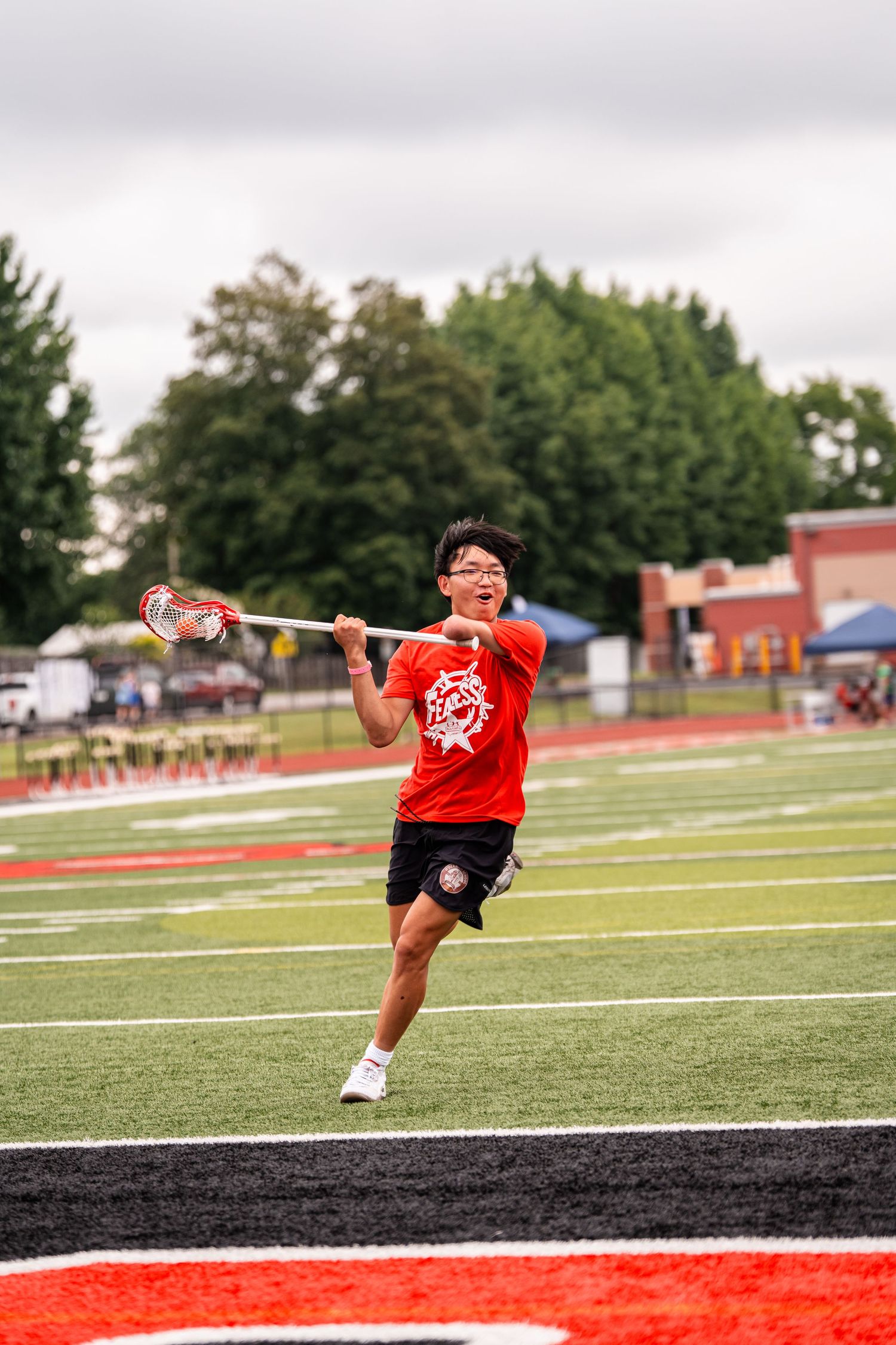 Athletes perform agility drills on a sports field with red and green turf markings.