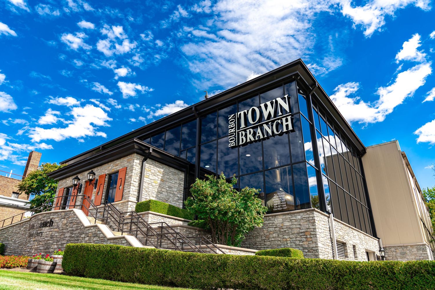 Exterior view of Town Branch distillery buildings under bright blue sky.