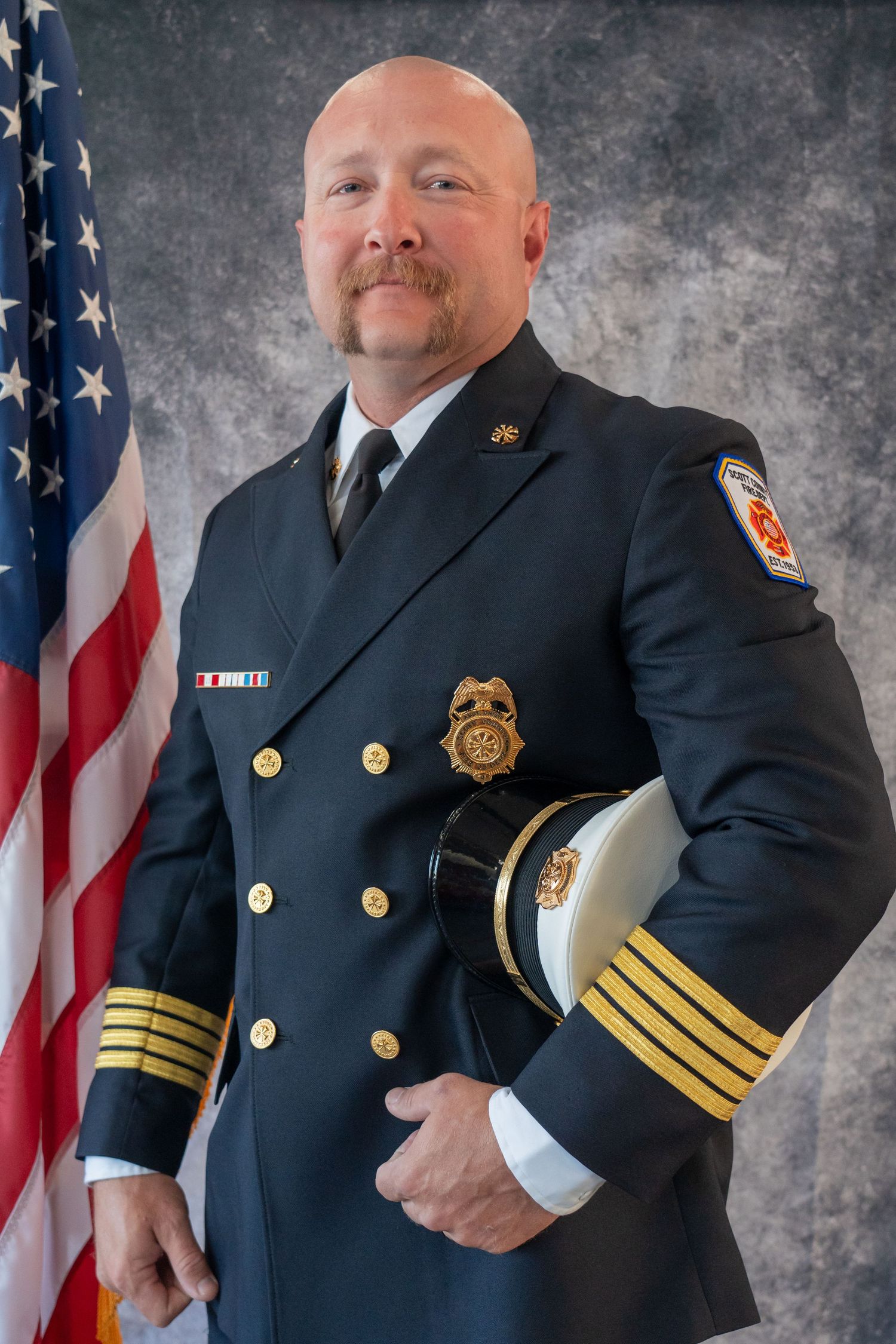 Fire department officers in dress uniforms posing for official portraits.