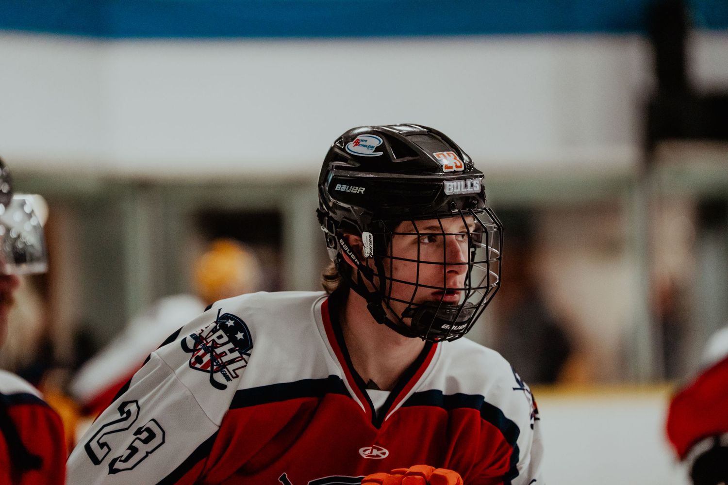 Hockey players in red jerseys competing during an intense match.