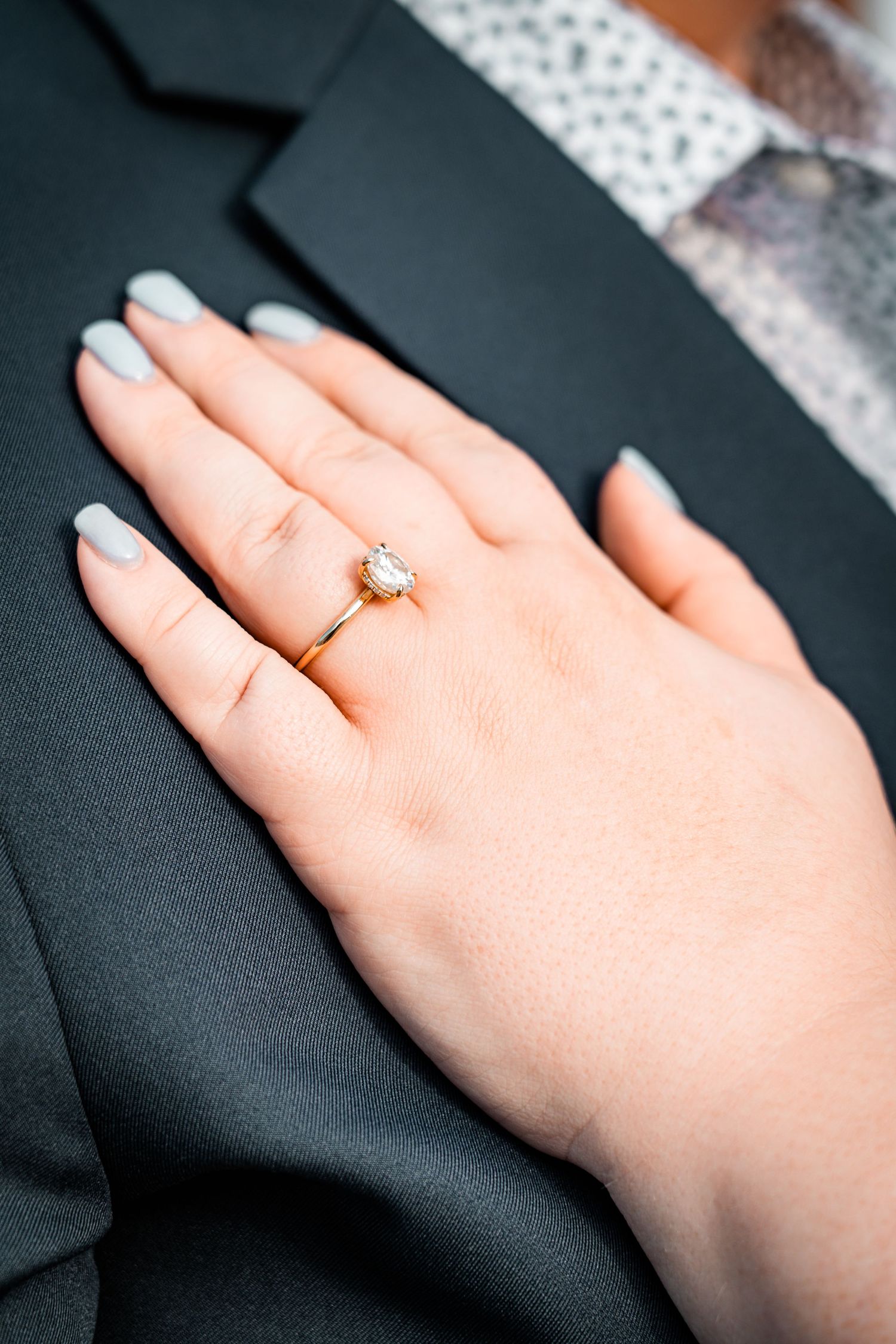 Close-up sequence of a hand wearing a gold ring against a dark suit jacket.
