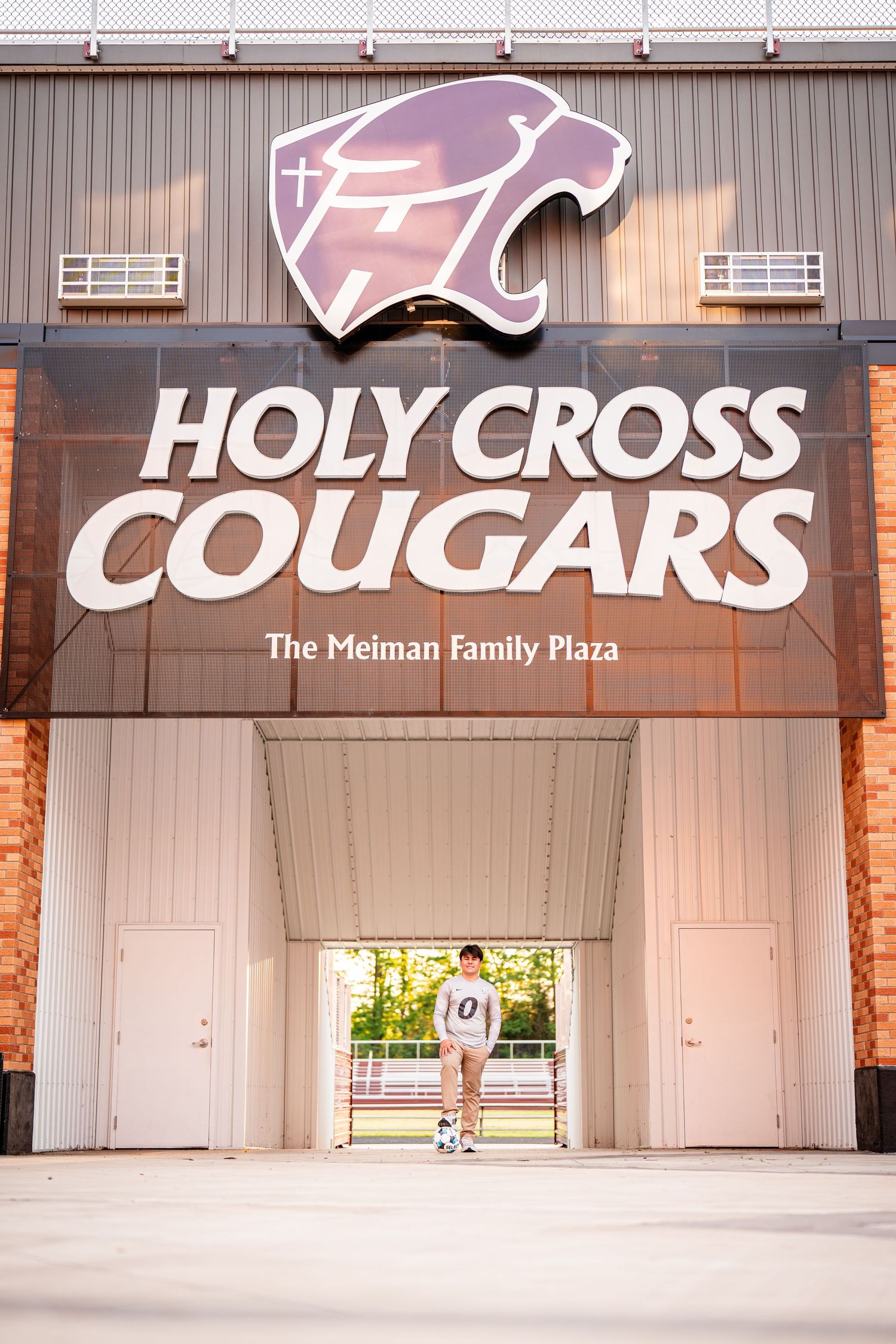 Holy Cross Cougars athletic facility entrance with illuminated signage.