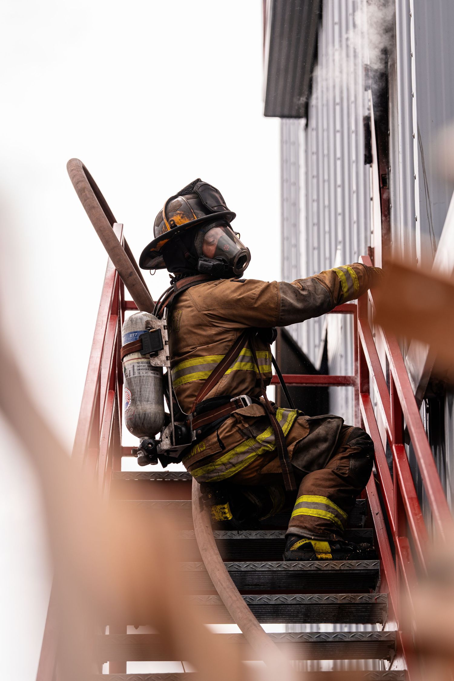 Firefighter in full gear crawls through a training course demonstrating search and rescue techniques.