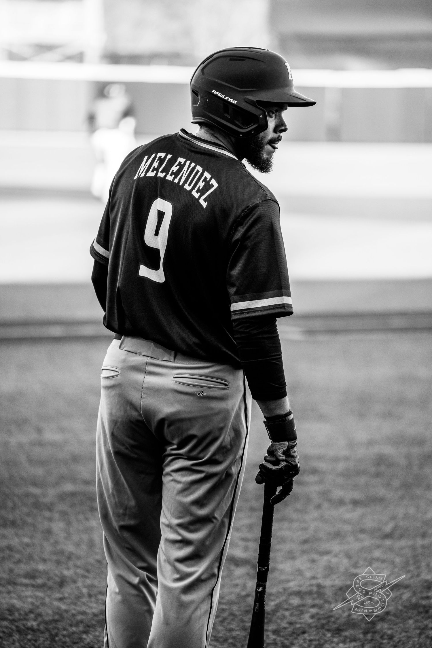 Baseball players in uniforms stand on the field during a game.