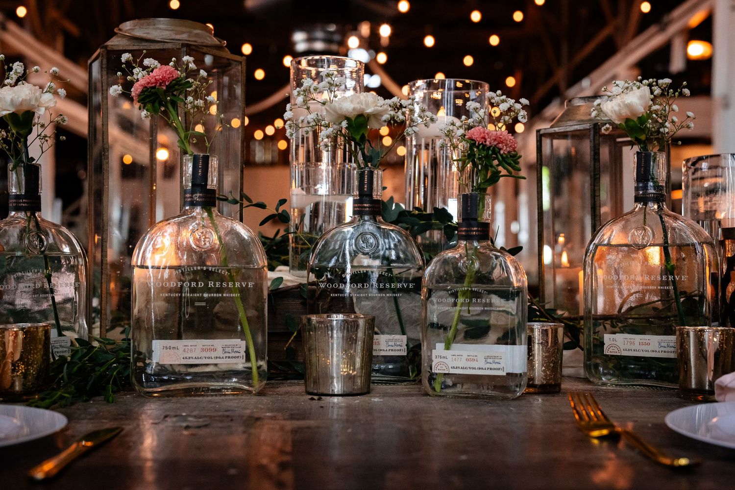 Glass bell jars with floral arrangements and soft lighting create an enchanting table display.