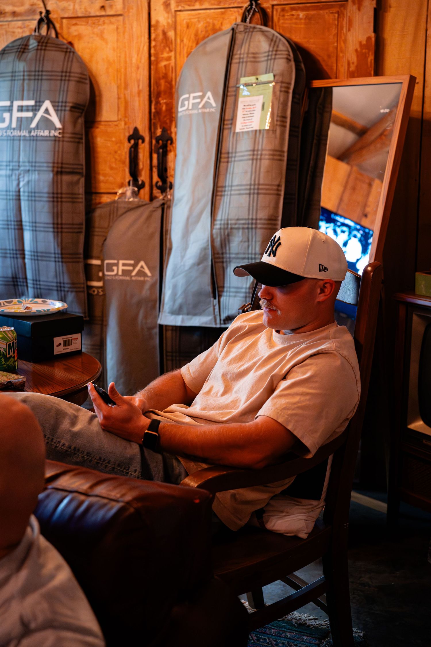 Groomsmen relaxing in casual attire inside a wooden cabin before the ceremony.