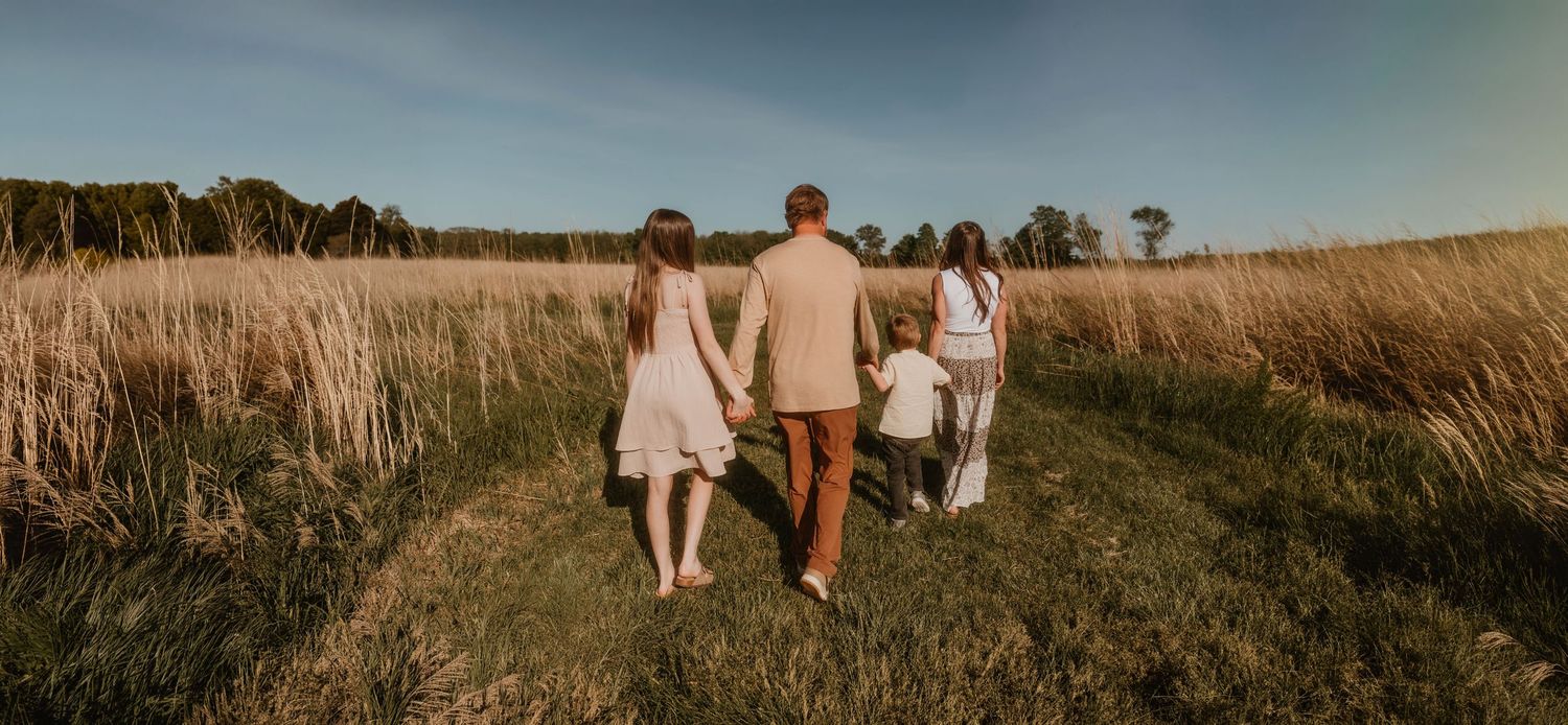 family with young children walking in a prairie