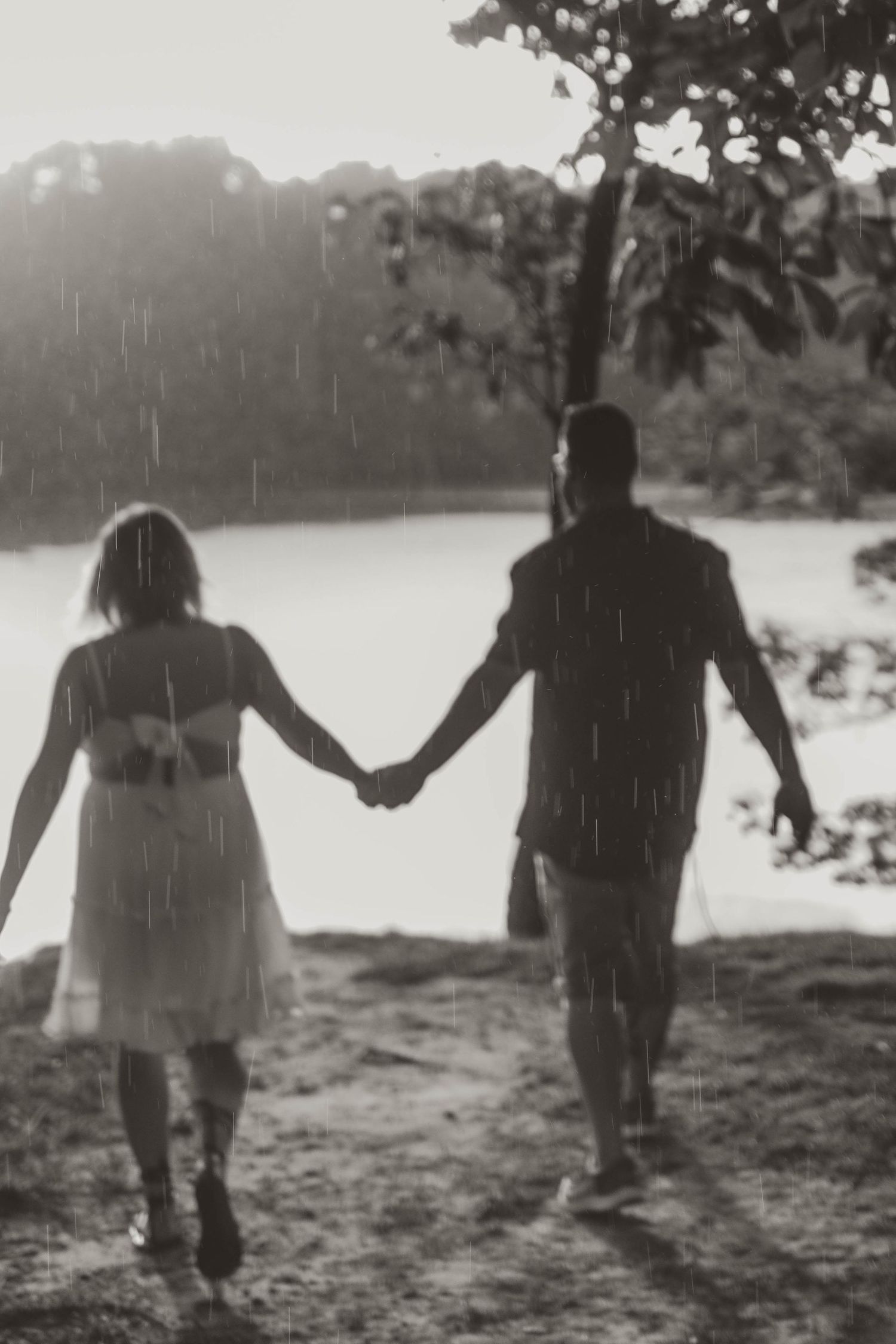 bride and groom dancing in the rain over looking the lake.