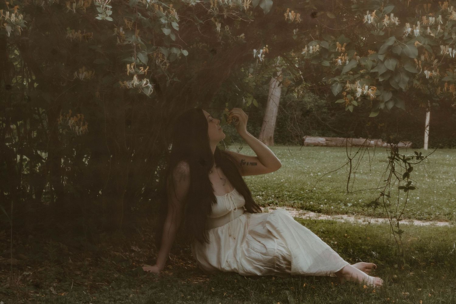 women resting and smelling honeysuckle flowers