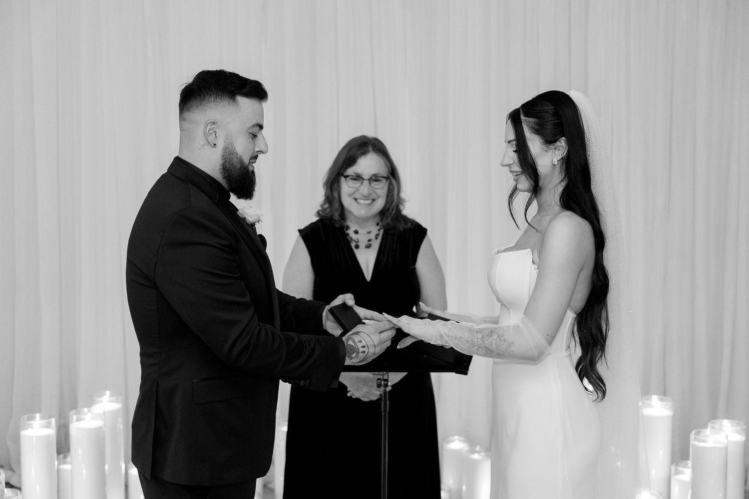 Couple exchanges rings during intimate ceremony with officiant.