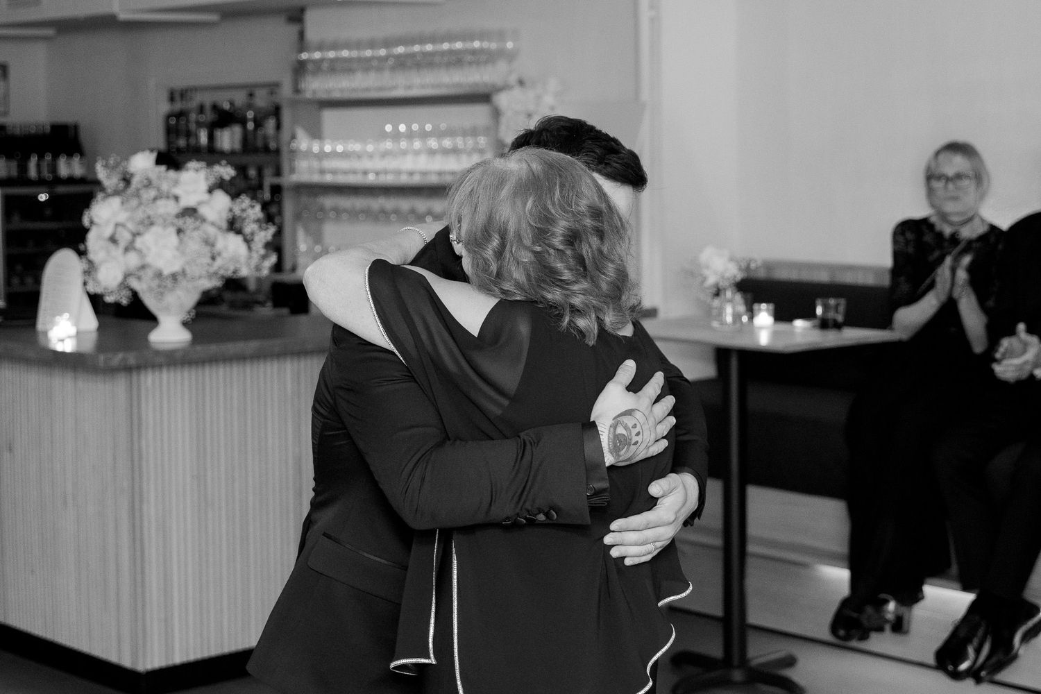 Intimate dance moments at a wedding reception with guests in formal black and white attire.