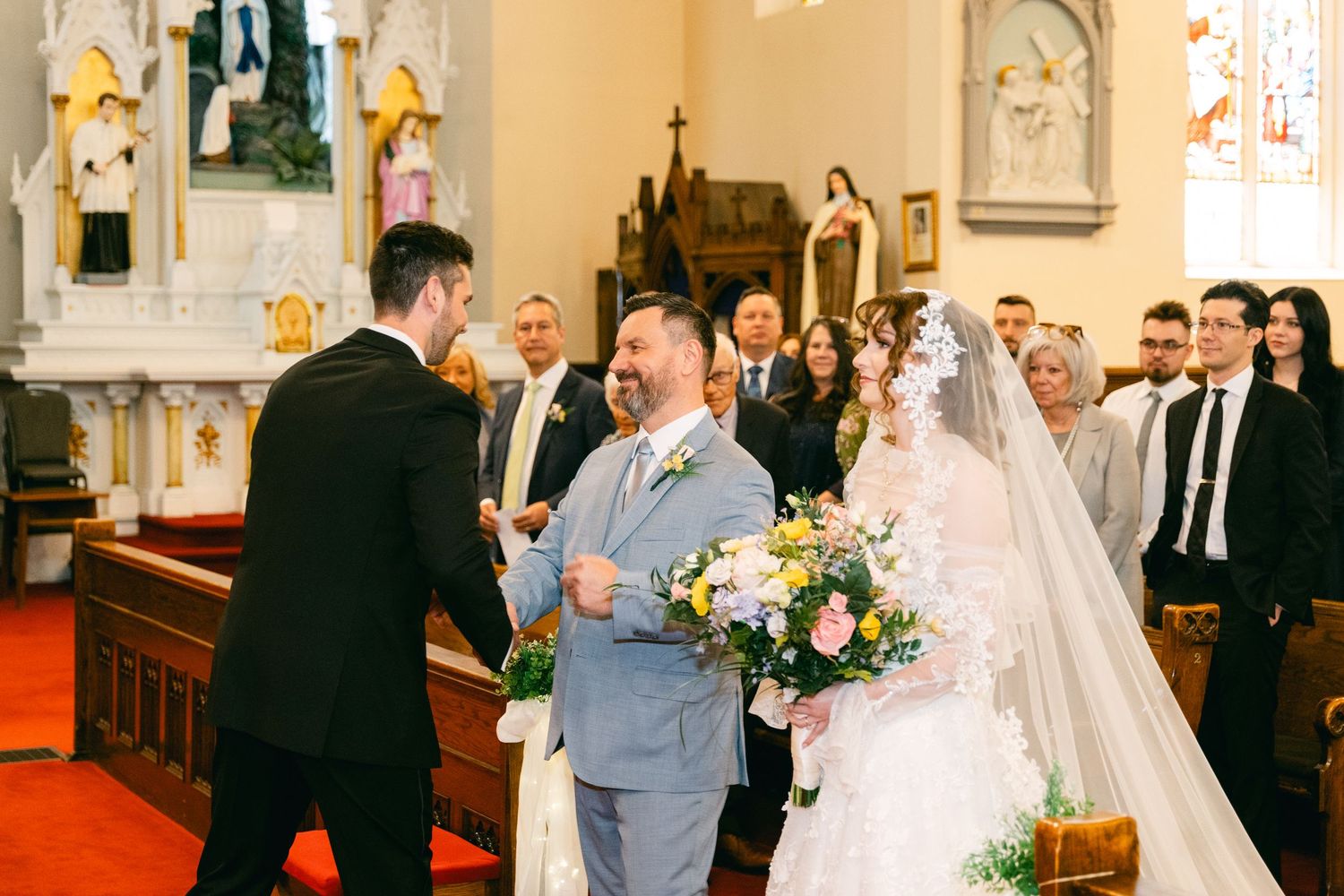 Bride and groom exchange vows at a church wedding ceremony, with guests seated in pews.