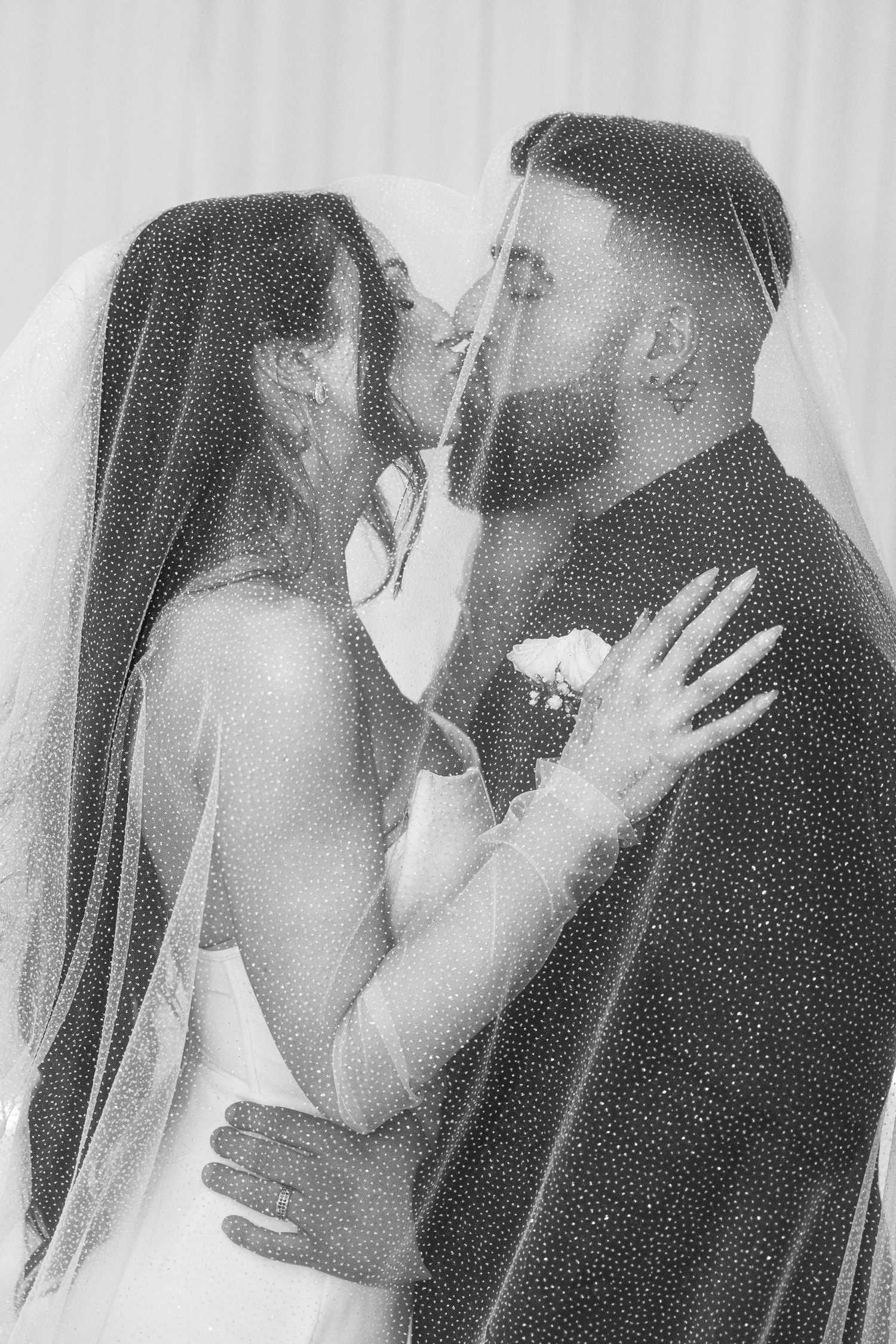 Intimate black and white wedding portrait featuring a tender moment between newlyweds.
