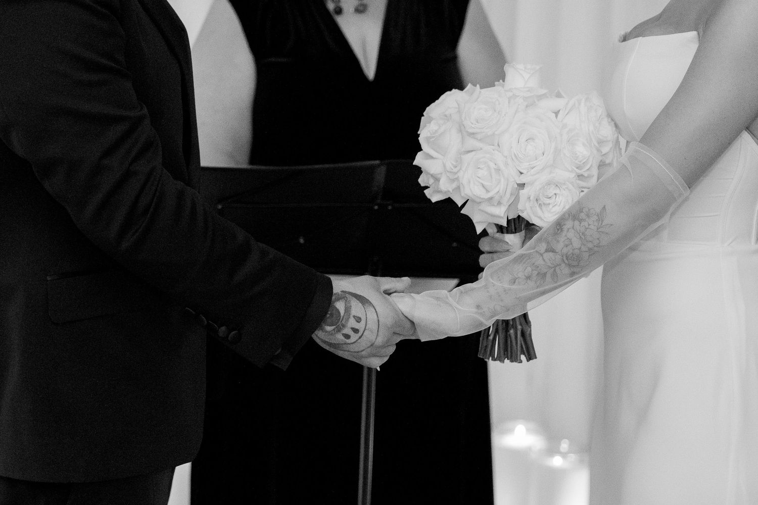 Intimate wedding moments captured with guests in black formal wear against white backdrop.