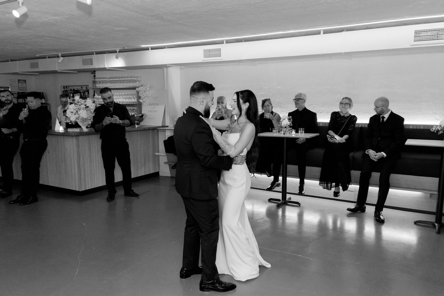 A romantic first dance in black and white at an intimate wedding reception.