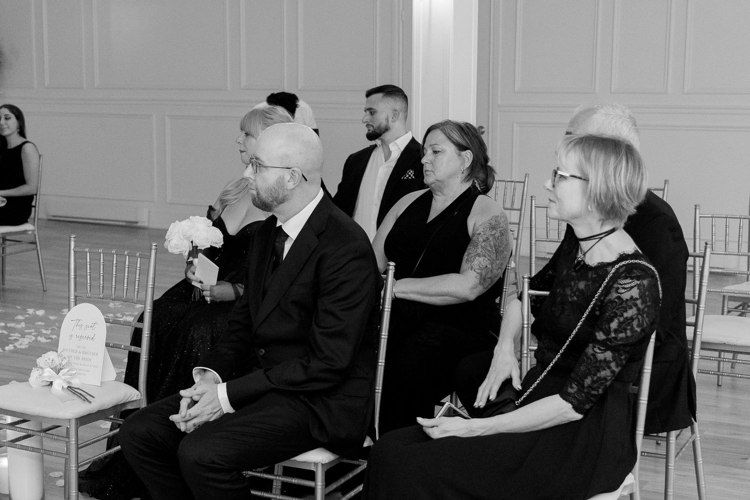 People sitting in formal business attire listen attentively during what appears to be a professional meeting or conference.