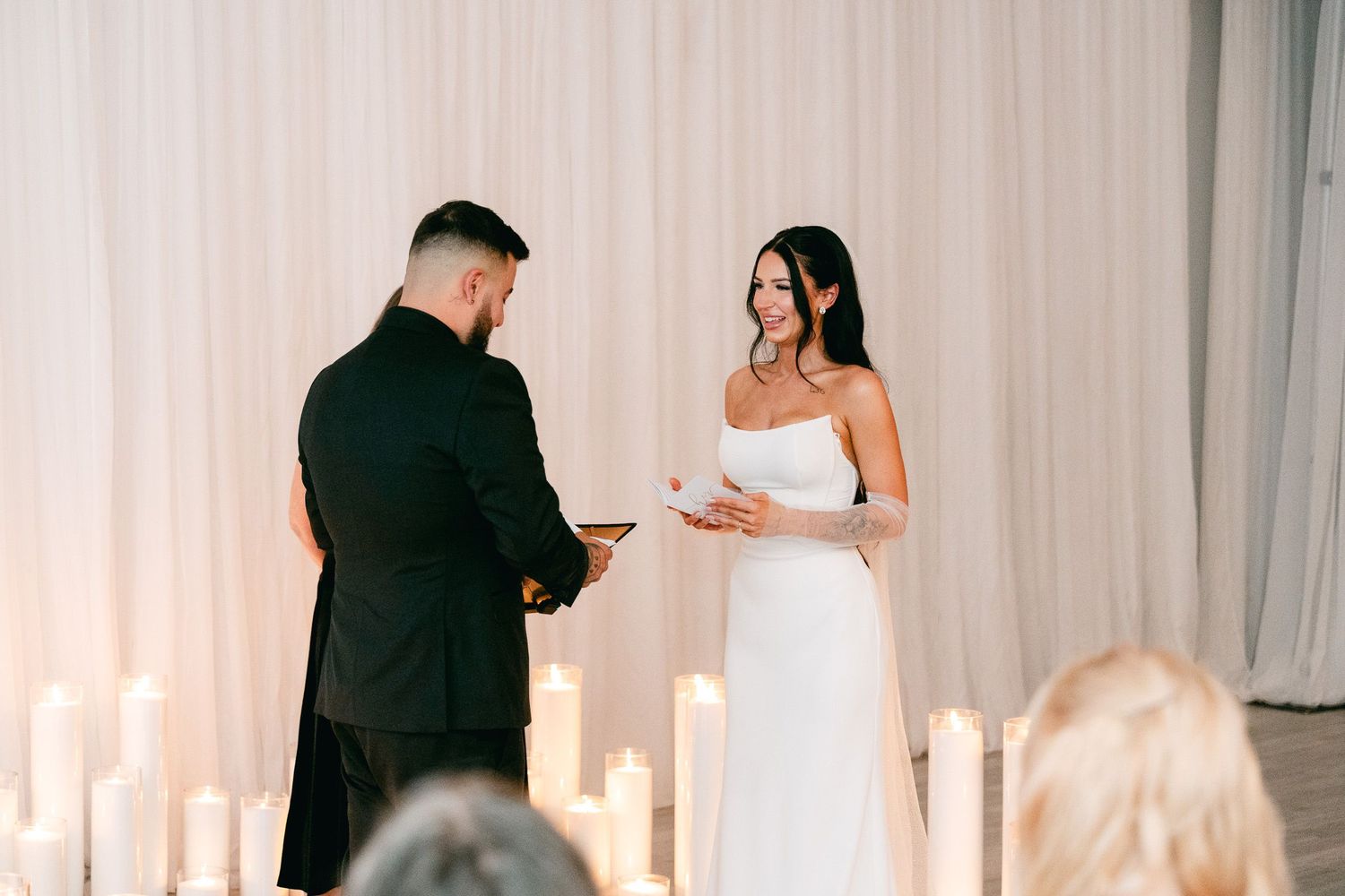 Couple exchanges vows during intimate candlelit wedding ceremony.