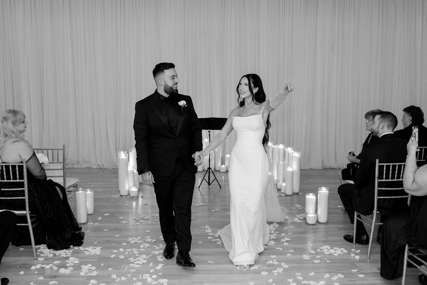 Wedding ceremony setup with scattered rose petals and Chiavari chairs.