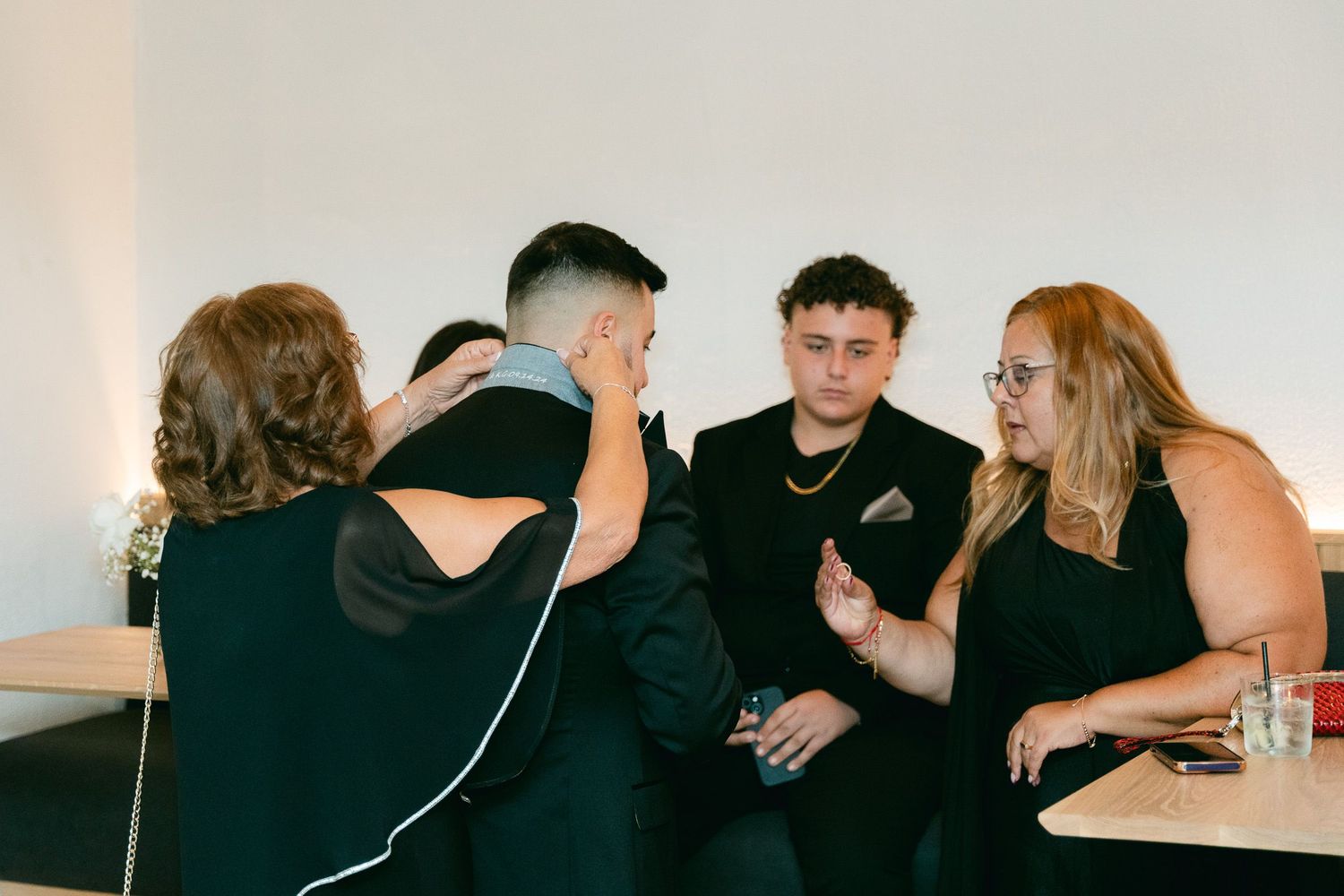Wedding guests enjoying conversation at a reception table in casual setting.