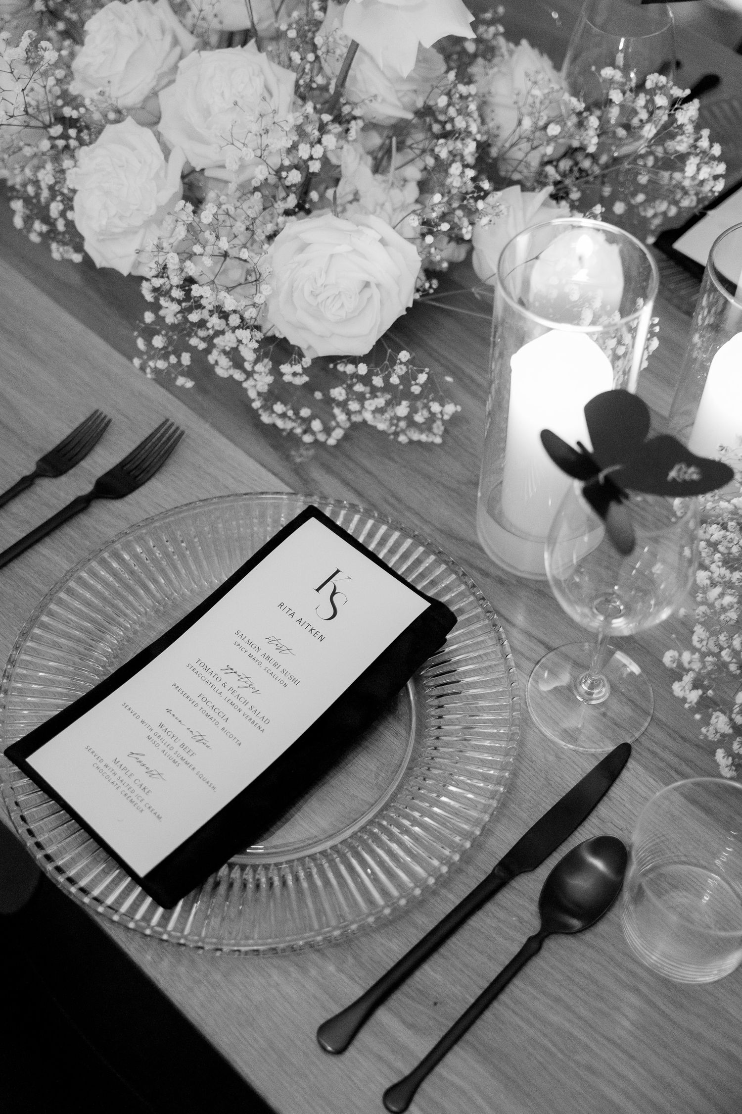 Elegant wedding table setting with glass charger plates and floral centerpieces.