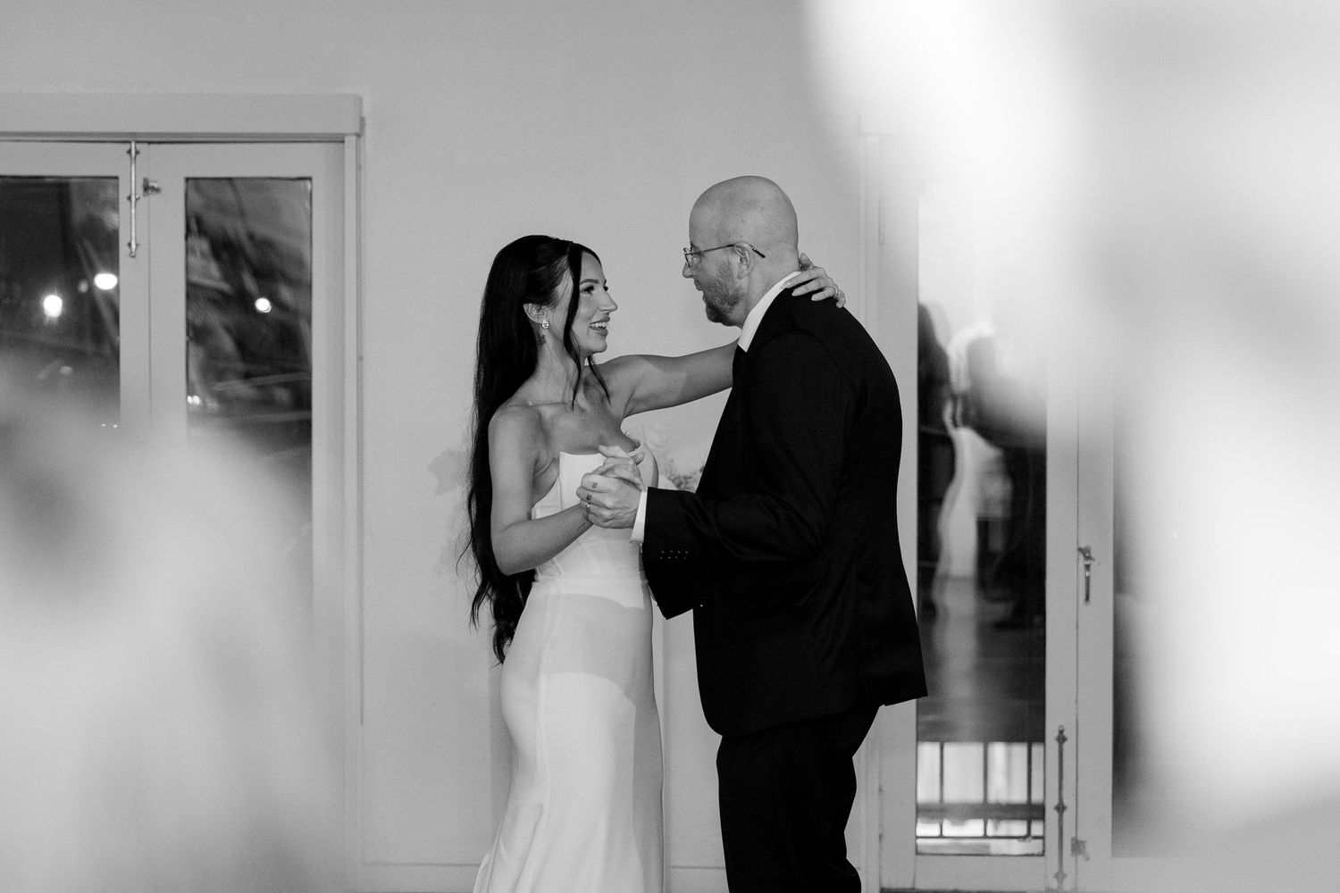 Wedding celebration captured in black and white with dancers enjoying formal attire and elegant movements.
