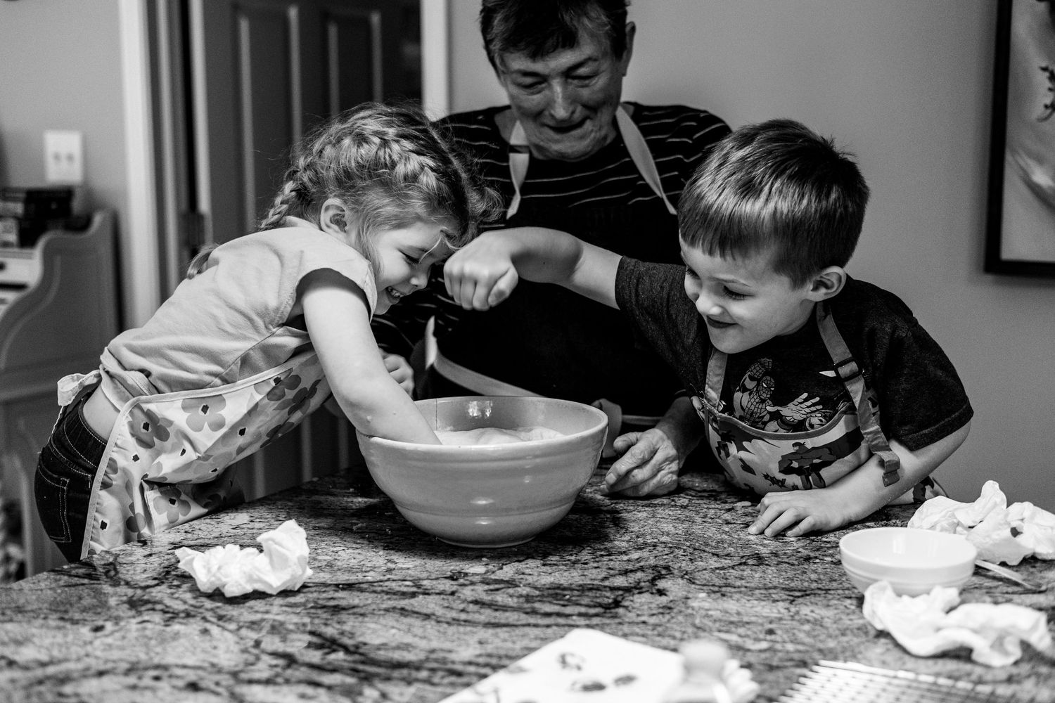 A series of black and white photographs showing children playing with flour and dough while baking in a kitchen.