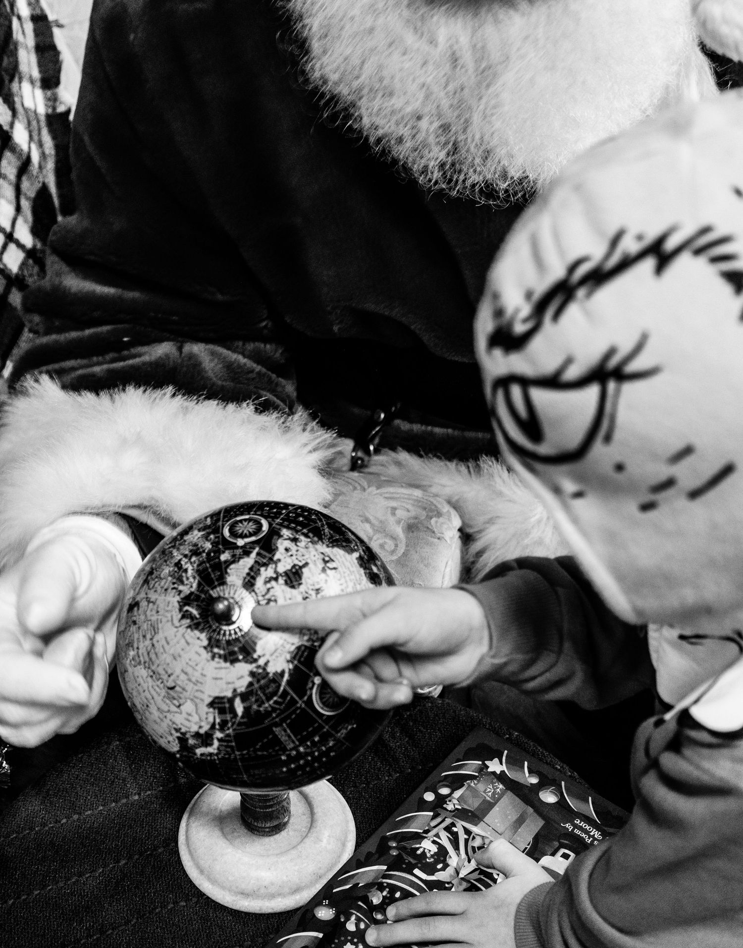 Black and white close-up images of hands decorating Christmas cookies with frosting and sprinkles.
