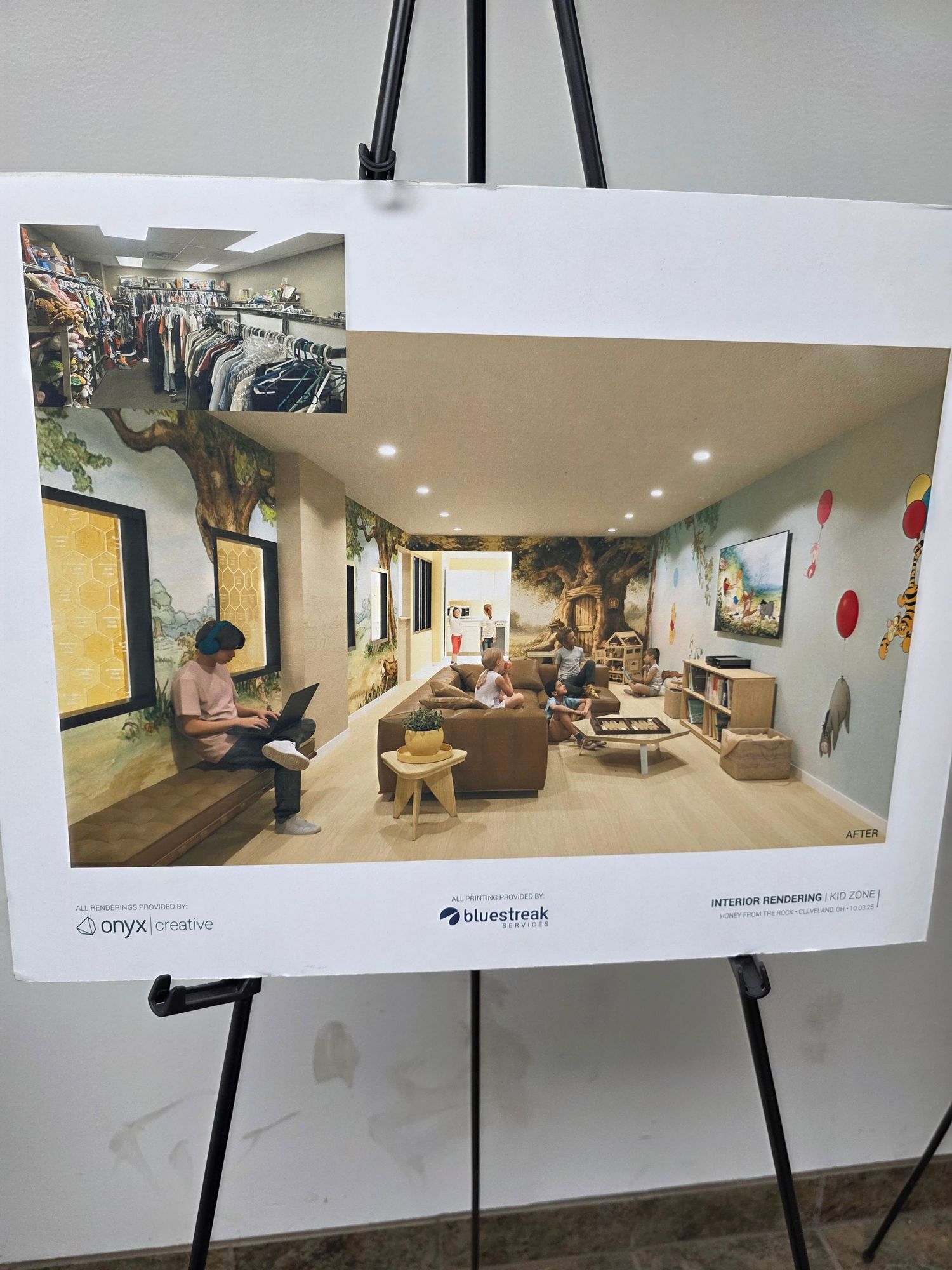 Interior design rendering displayed on an easel showing a modern lounge space with tree mural, seating area, and clothing rack.