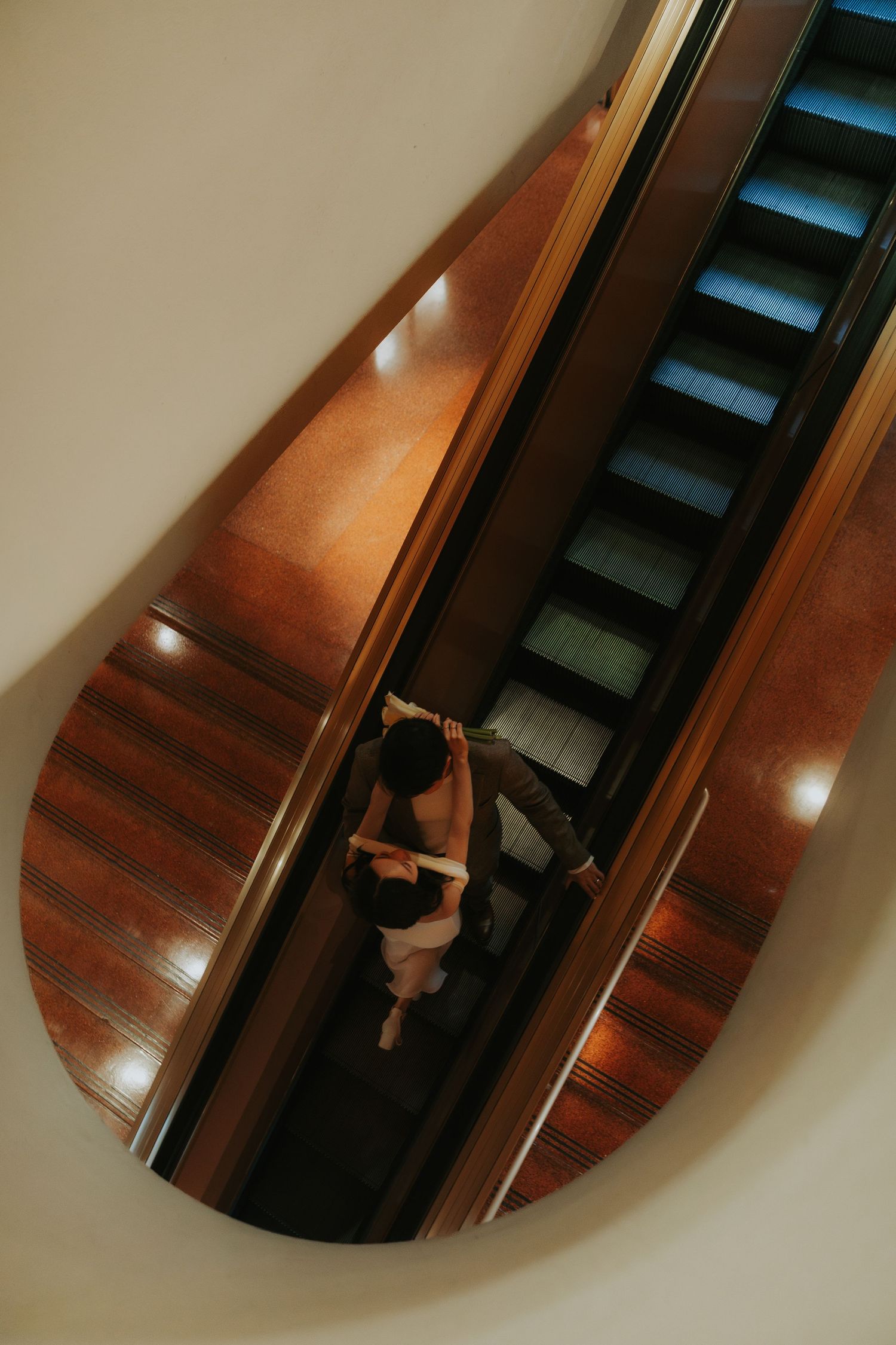 A series of wooden stairs with warm lighting creates a dramatic diagonal composition in an interior space.