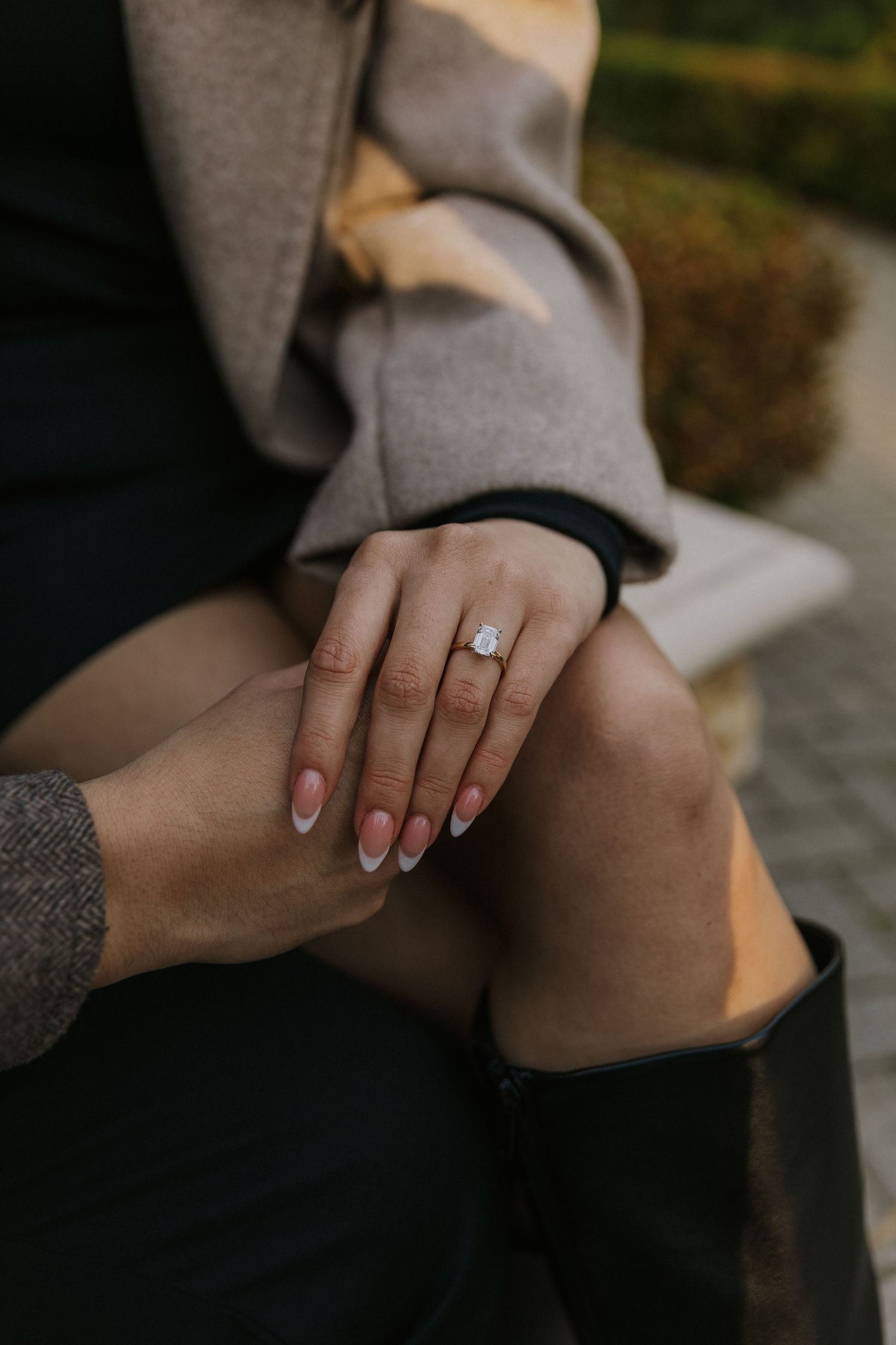 Close-up photos showing hands with an engagement ring in various poses against a dark background.