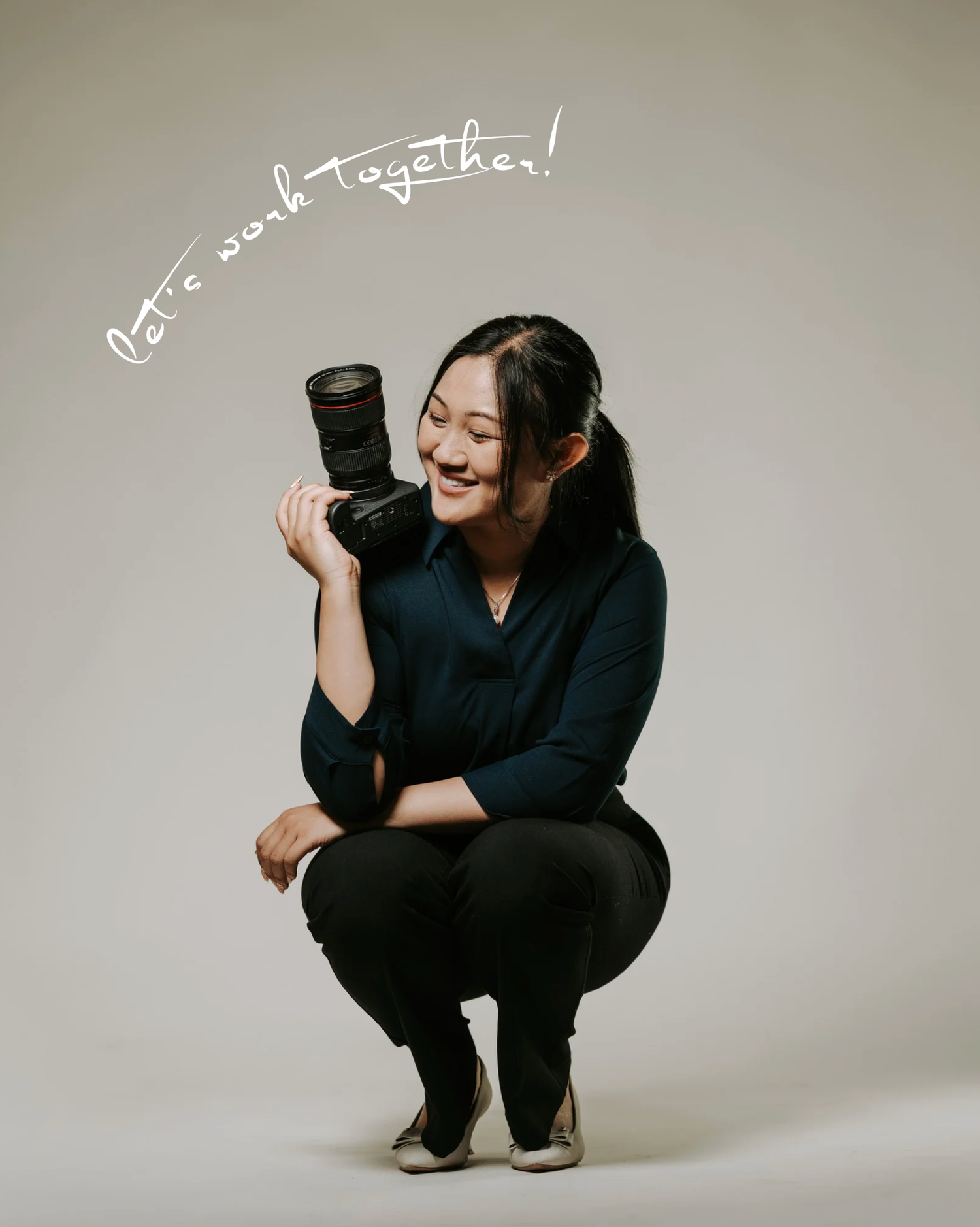 Person in all black attire crouches and poses expressively against neutral studio backdrop in artistic photo series.